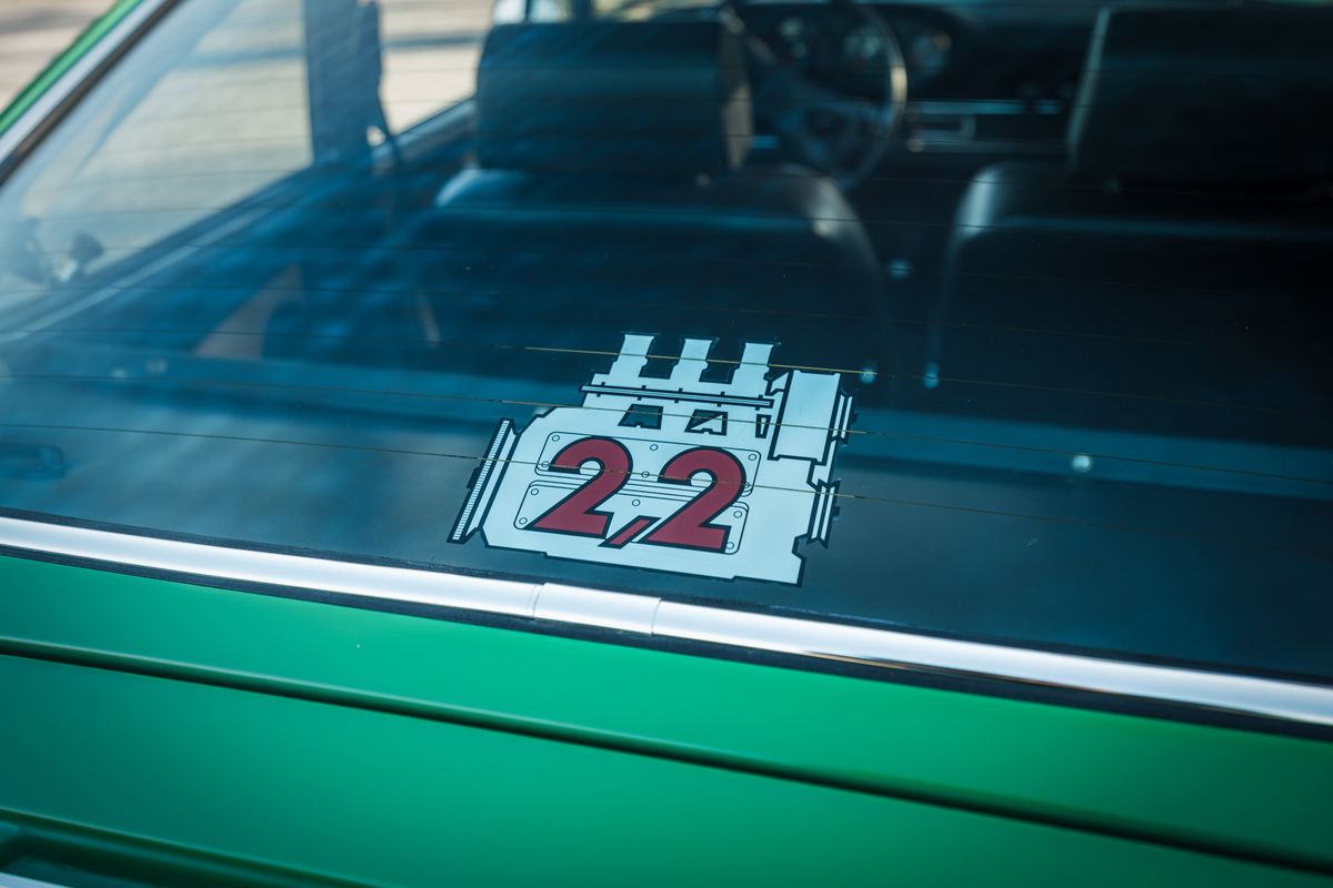 Conda Green 1971 Porsche 911E rear window displaying a custom 2.2L flat-six engine decal and chrome trim.