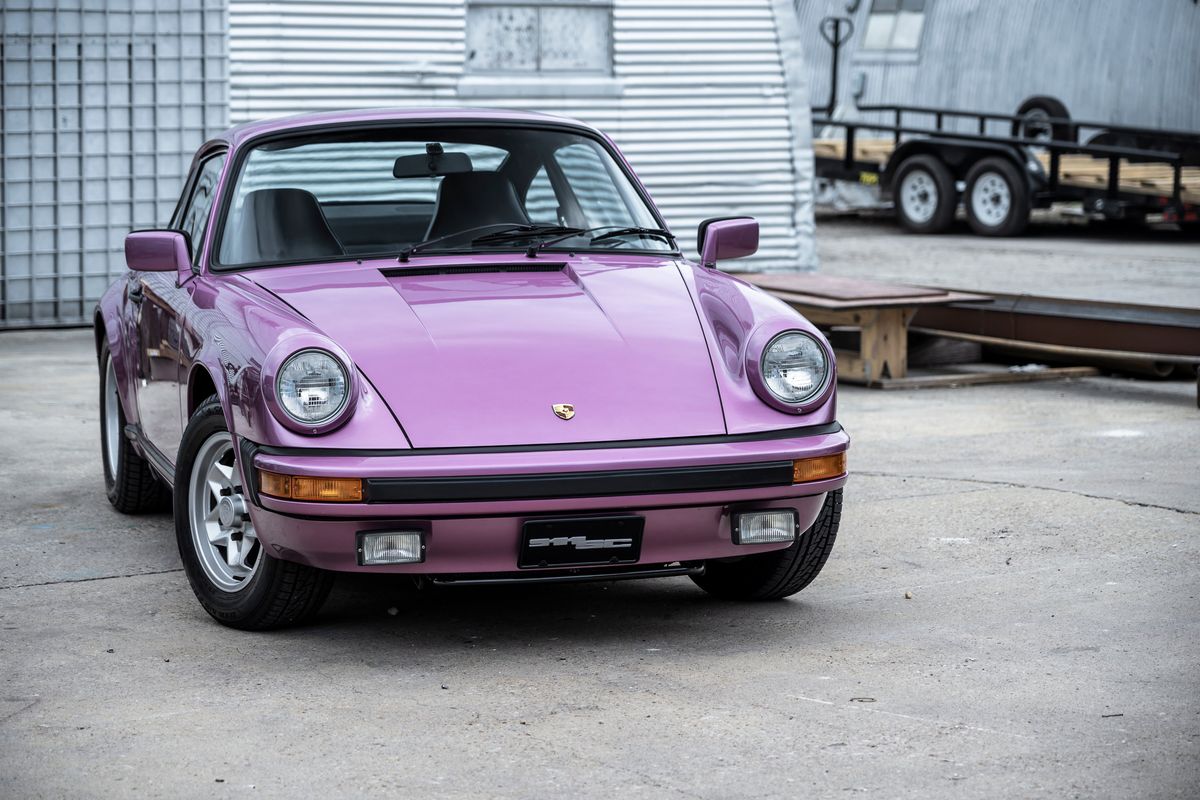 Front view of a striking purple Porsche 911 (G-Series) with classic Fuchs-style rims and black trim details.