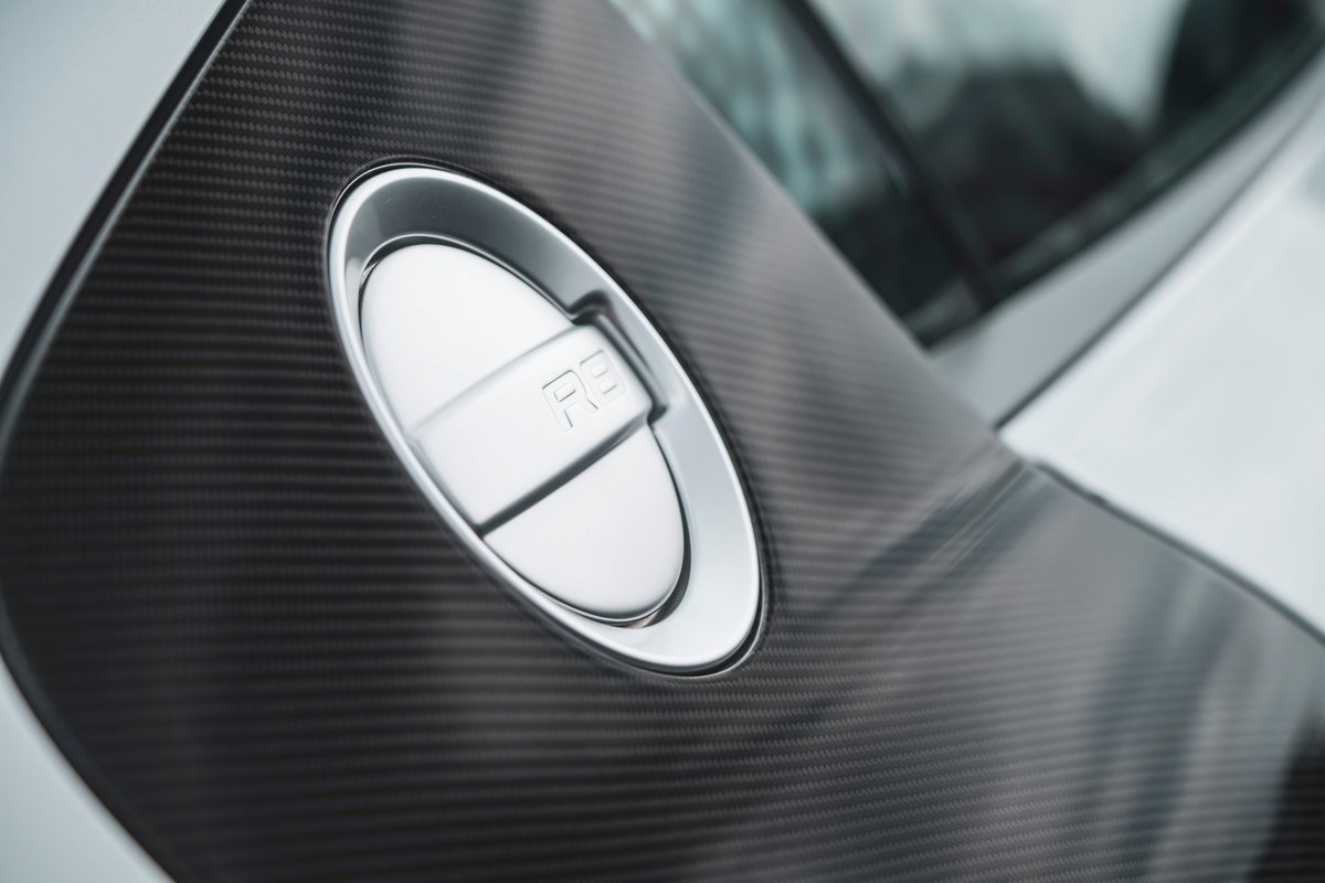 Silver Audi R8 supercar close-up: carbon fiber side blade details the prominent metallic R8 fuel filler cap.