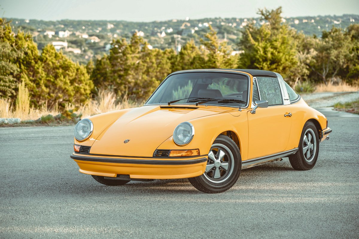Bright Signal Yellow 1973 Porsche 911S Targa, featuring a silver Targa bar, classic Fuchs rims, and slim chrome trim.