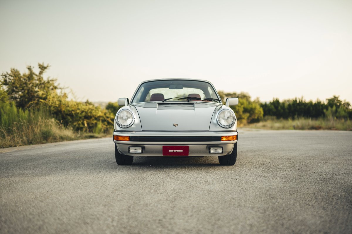 Silver metallic 1977 Porsche 911S front fascia. Iconic headlights, rubber-padded bumper with integrated fog lights.