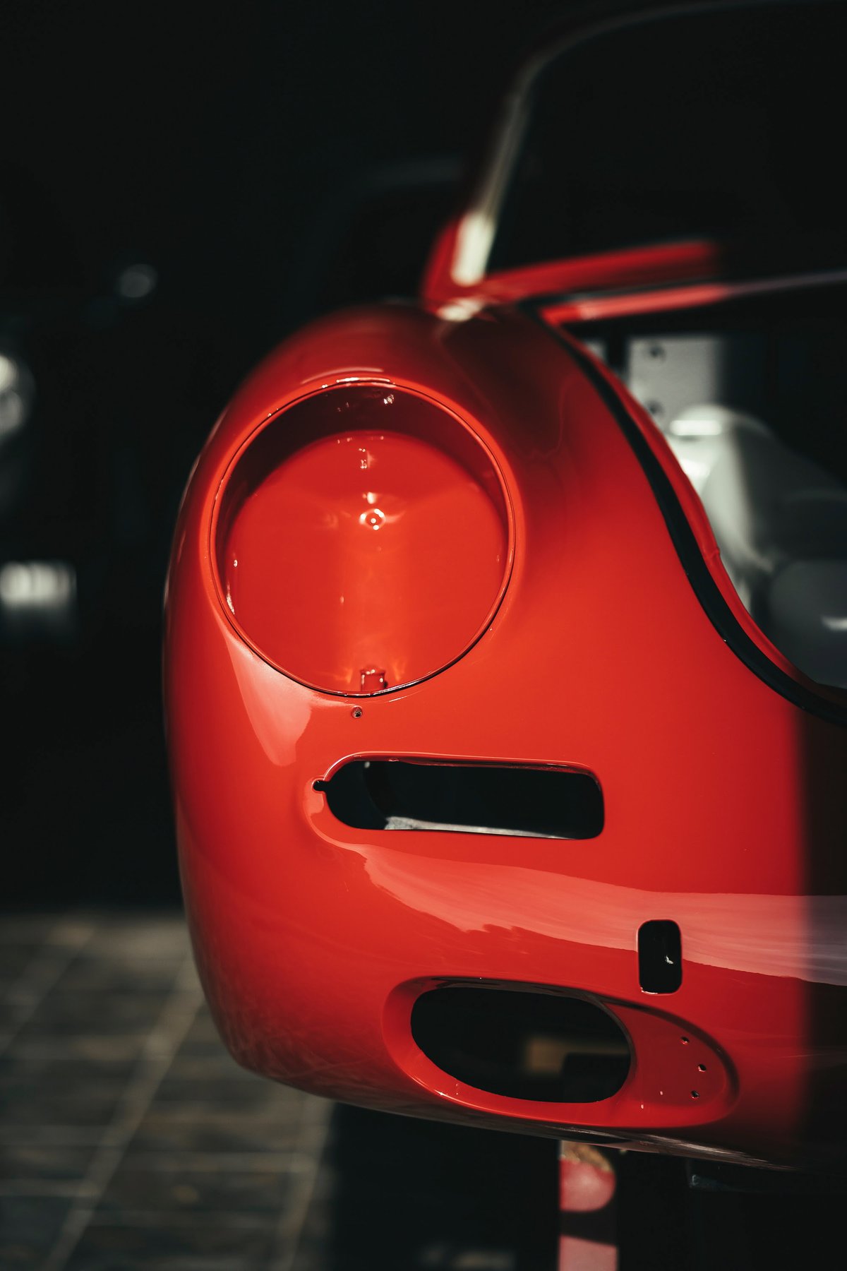 Vintage Rosso Corsa Ferrari 250 GTO body panel showing open headlight bucket, brake cooling ducts & front fascia details.
