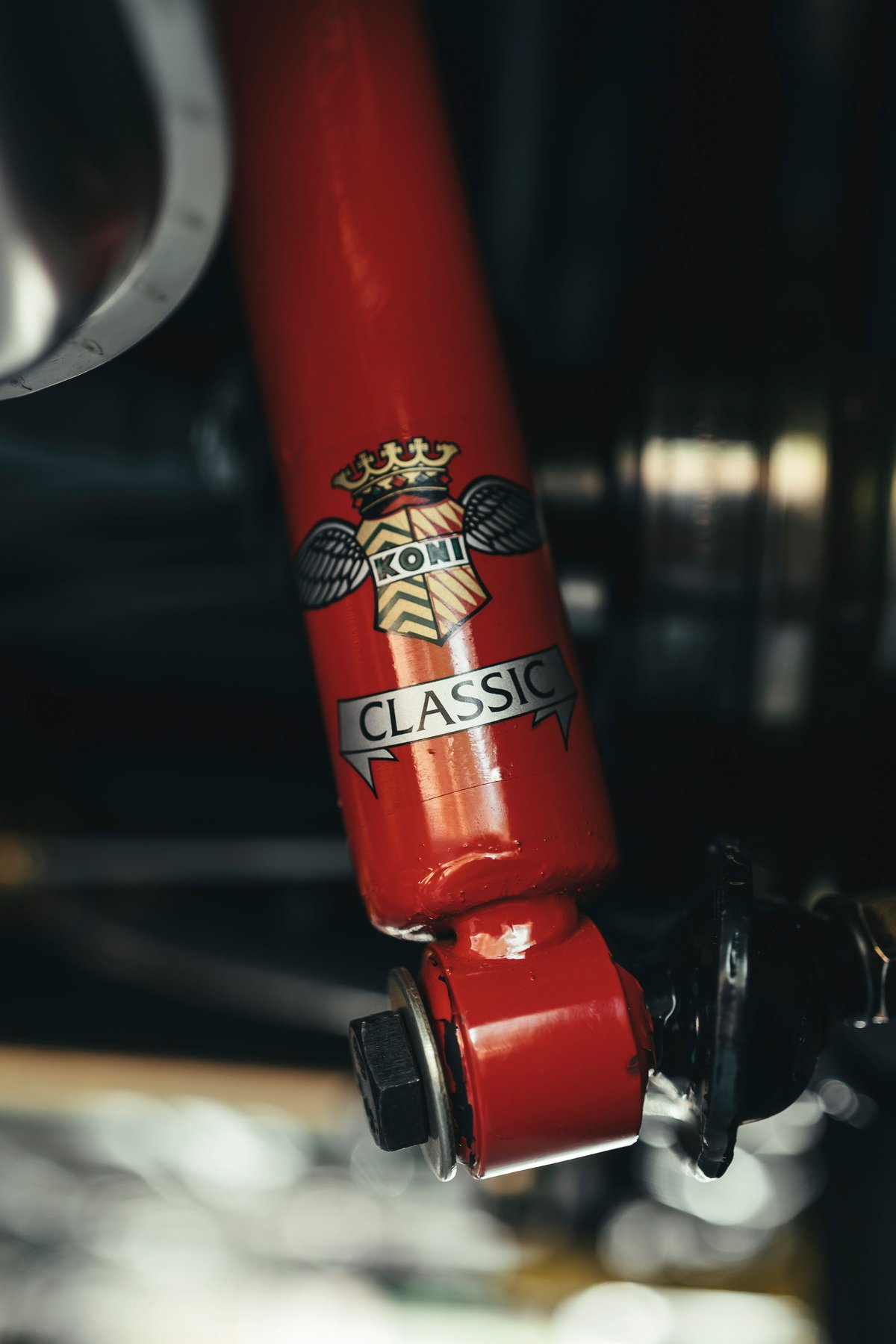 Close-up of a red Koni Classic shock absorber, an essential performance suspension upgrade for vintage and restored cars.