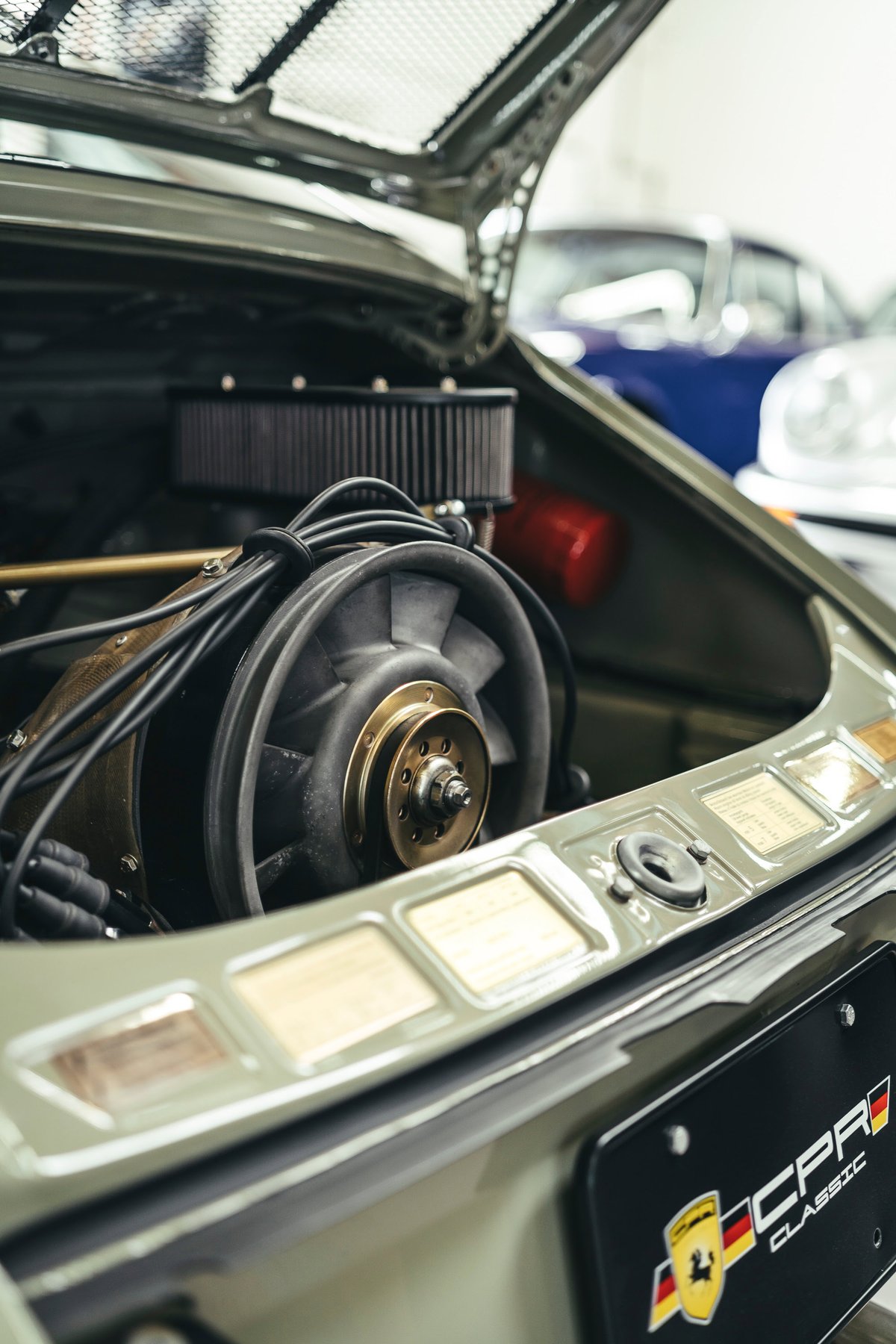 Classic olive green Porsche 911's air-cooled flat-six engine. Performance air filter, gold fan pulley, and CPR Classic plate.