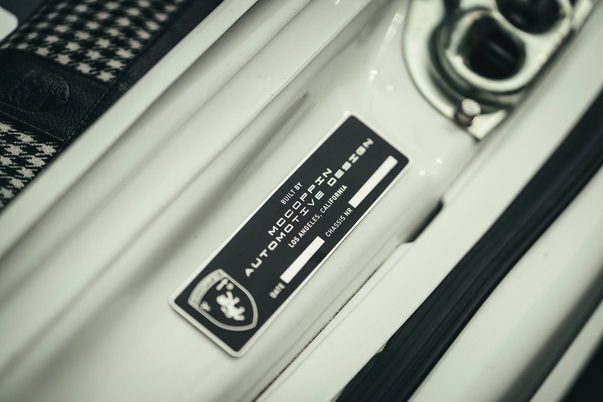 Custom white Porsche 911 by McCoppin Automotive Design. Close-up of door jamb builder's plate & houndstooth interior upholstery.