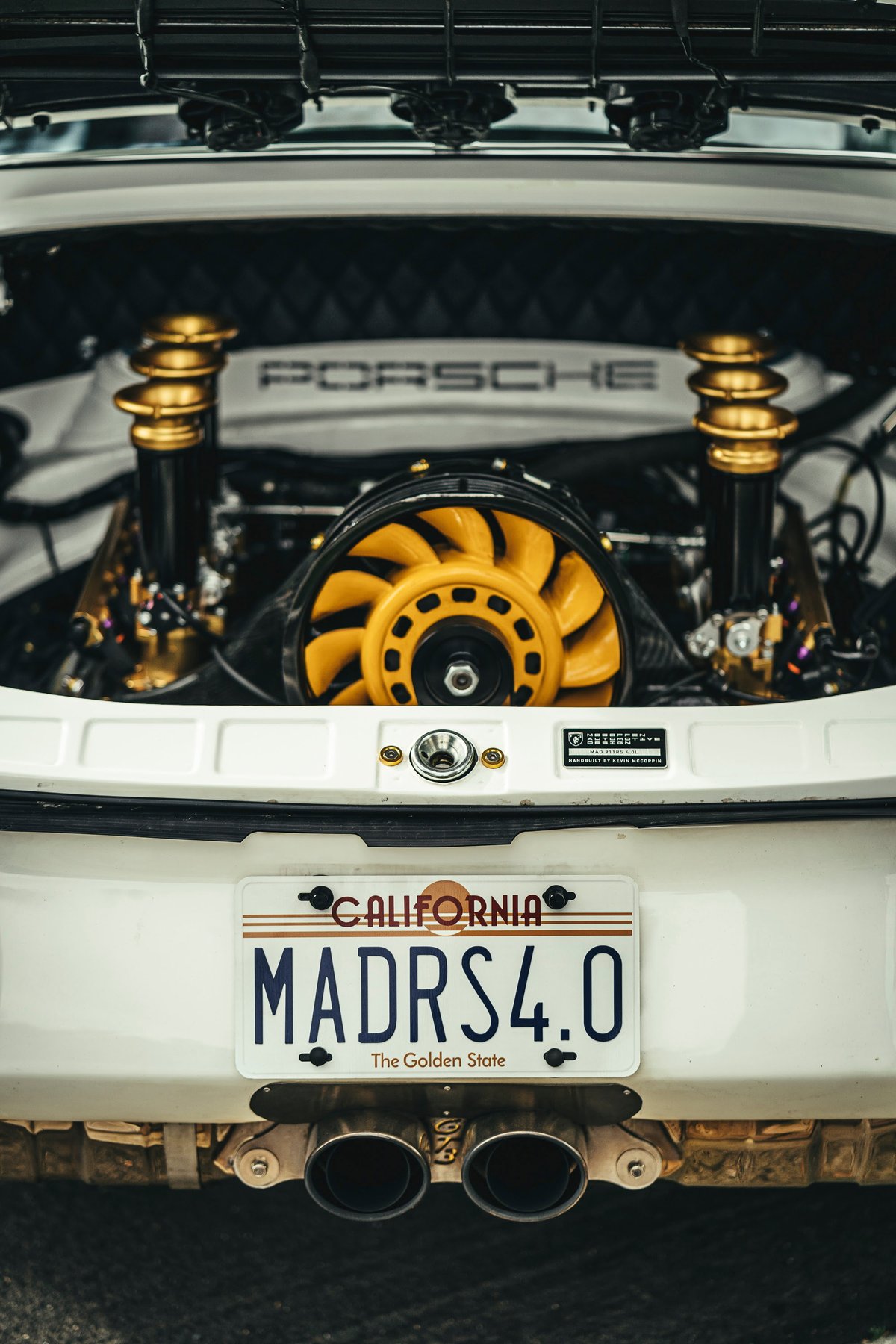 White Porsche 911 GT3 RS 4.0 rear, with exposed custom air-cooled flat-six engine bay, yellow fan, and gold coilovers.