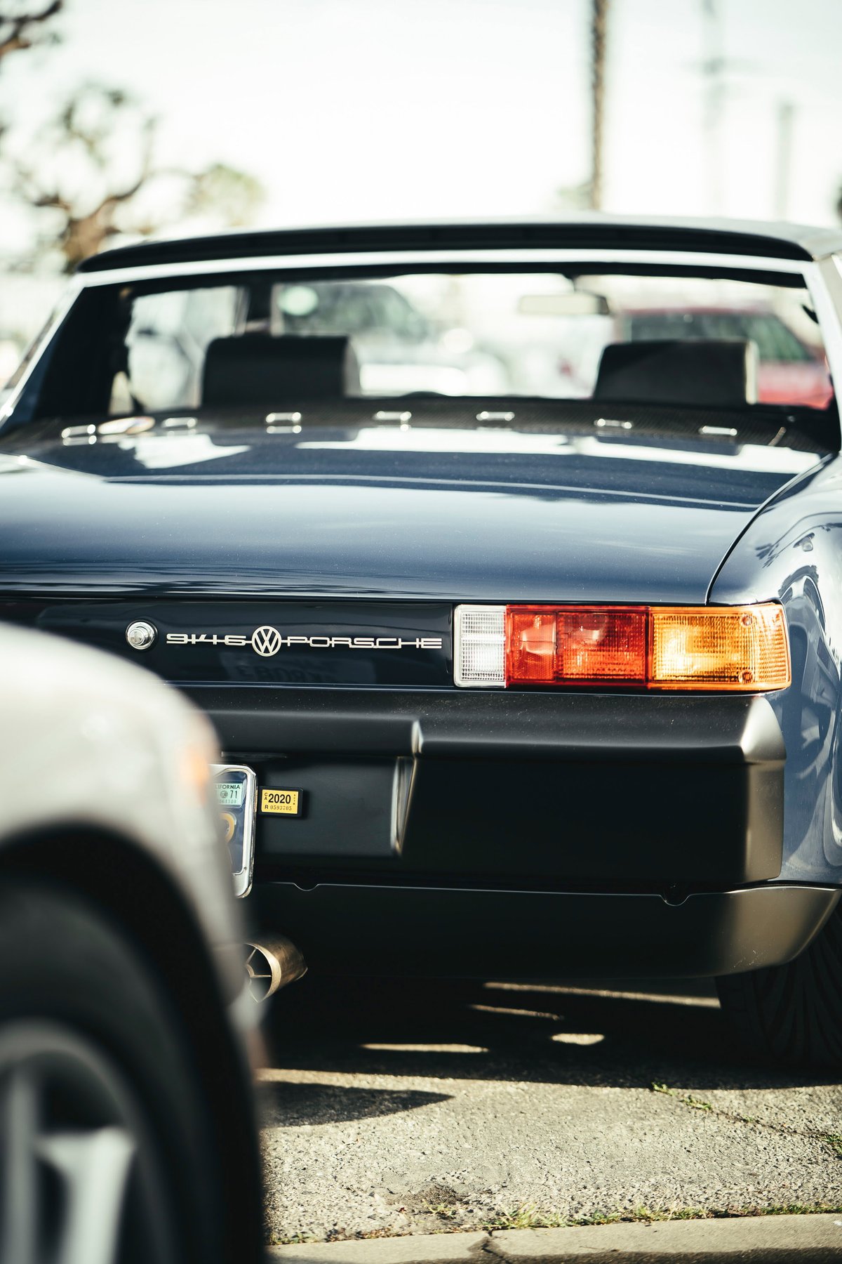 Dark blue 1970s Porsche 914-6 rear with "VW-Porsche" badging, rectangular taillights, and black trim at a Los Angeles show.
