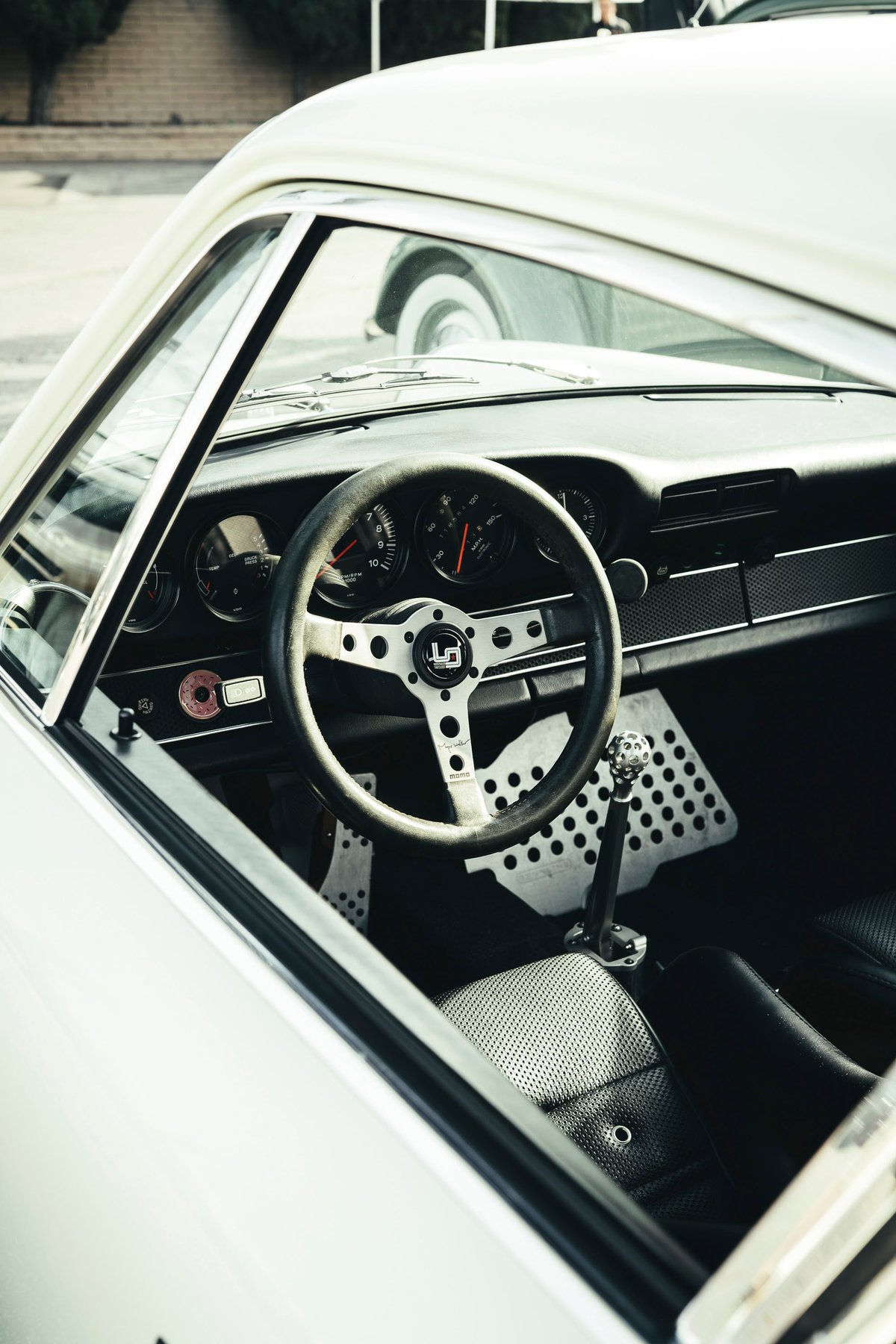 Classic white air-cooled Porsche 911 interior. 3-spoke performance steering wheel, drilled pedal box, short shifter, perforated seats.