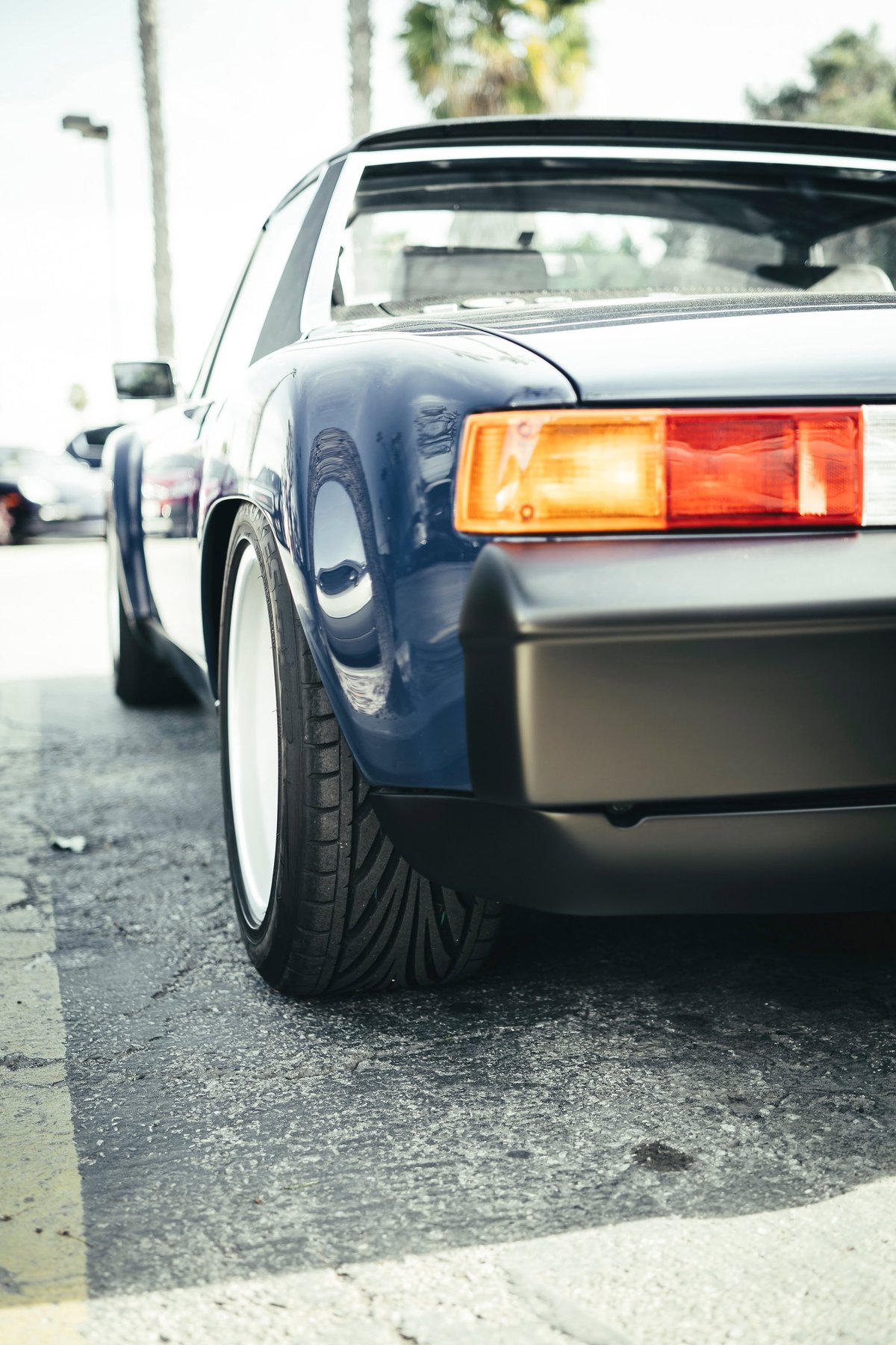 Custom blue Porsche 914 Targa rear. Widebody flares, white multi-spoke rims, performance tires, and iconic taillights at Luftgekühlt LA.