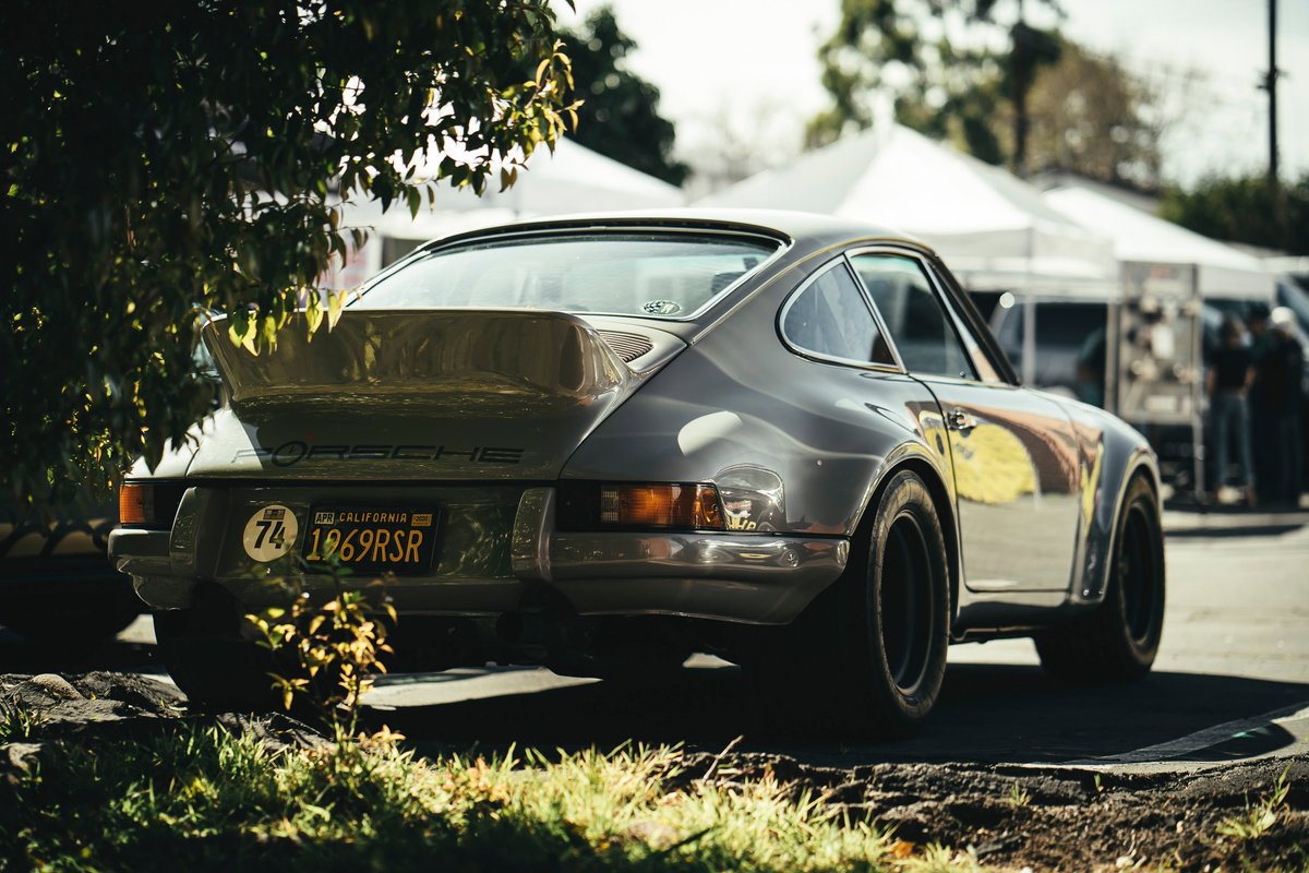 Vintage grey 1969 Porsche 911 RSR, wide body, deep dish black rims, whale tail spoiler, and retro livery detail.