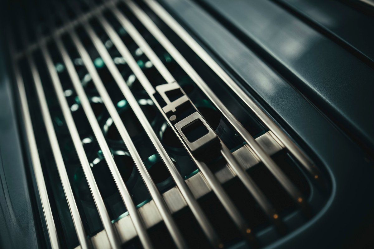 Close-up of a dark green Porsche 911 GT3 RS 4.0's rear engine cover, featuring its iconic '4.0' badge and vent grille.