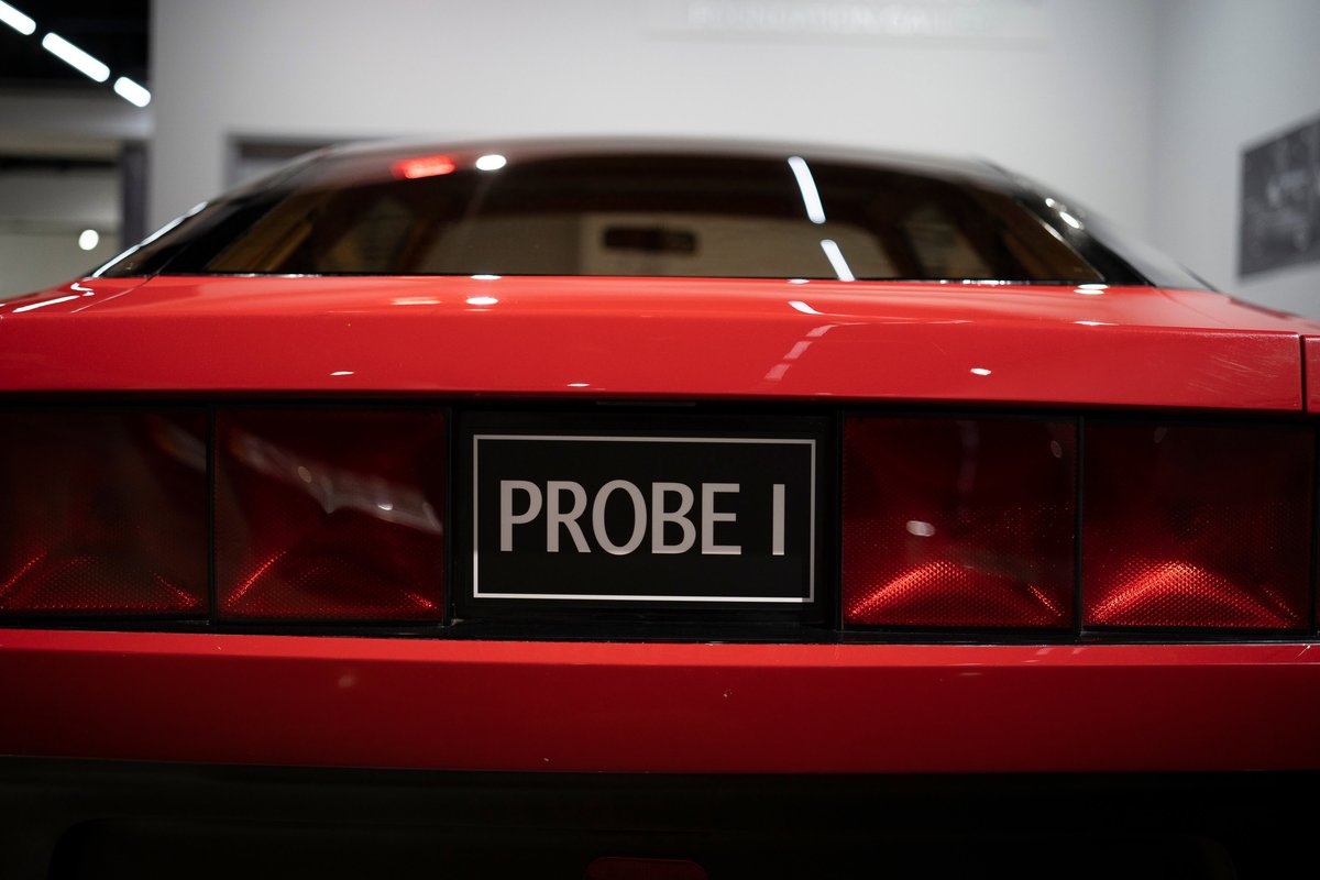 Rear view of the red Ford Probe I concept car, highlighting its wide taillight design and "PROBE I" badging.