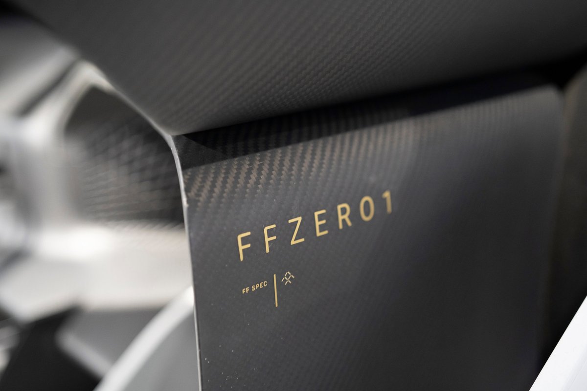 Faraday Future FFZERO1 concept's dark carbon fiber trim, featuring gold 'FFZERO1' branding and 'FF SPEC' detail.