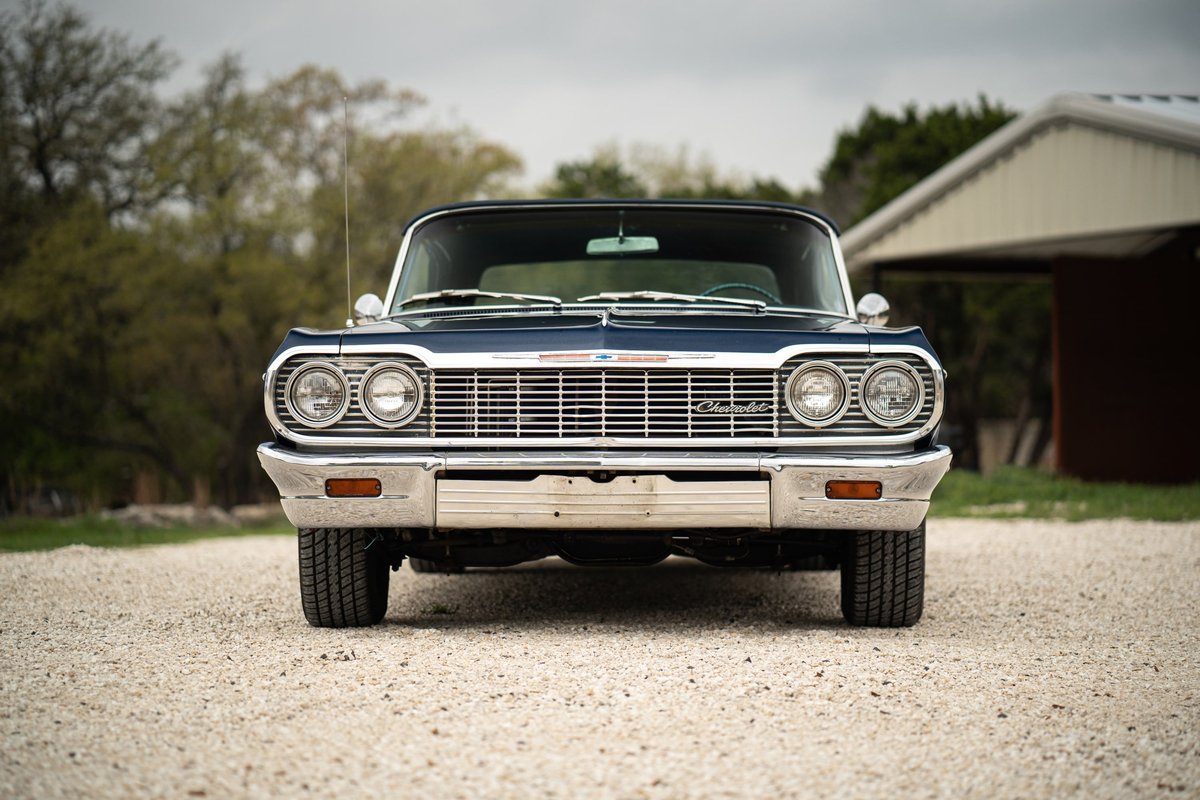 1964 Chevrolet Impala SS front view. Dark blue paint, chrome grille, and bumper.