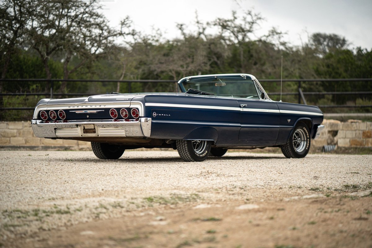 1964 Chevrolet Impala SS convertible in dark blue with chrome trim and classic rims.
