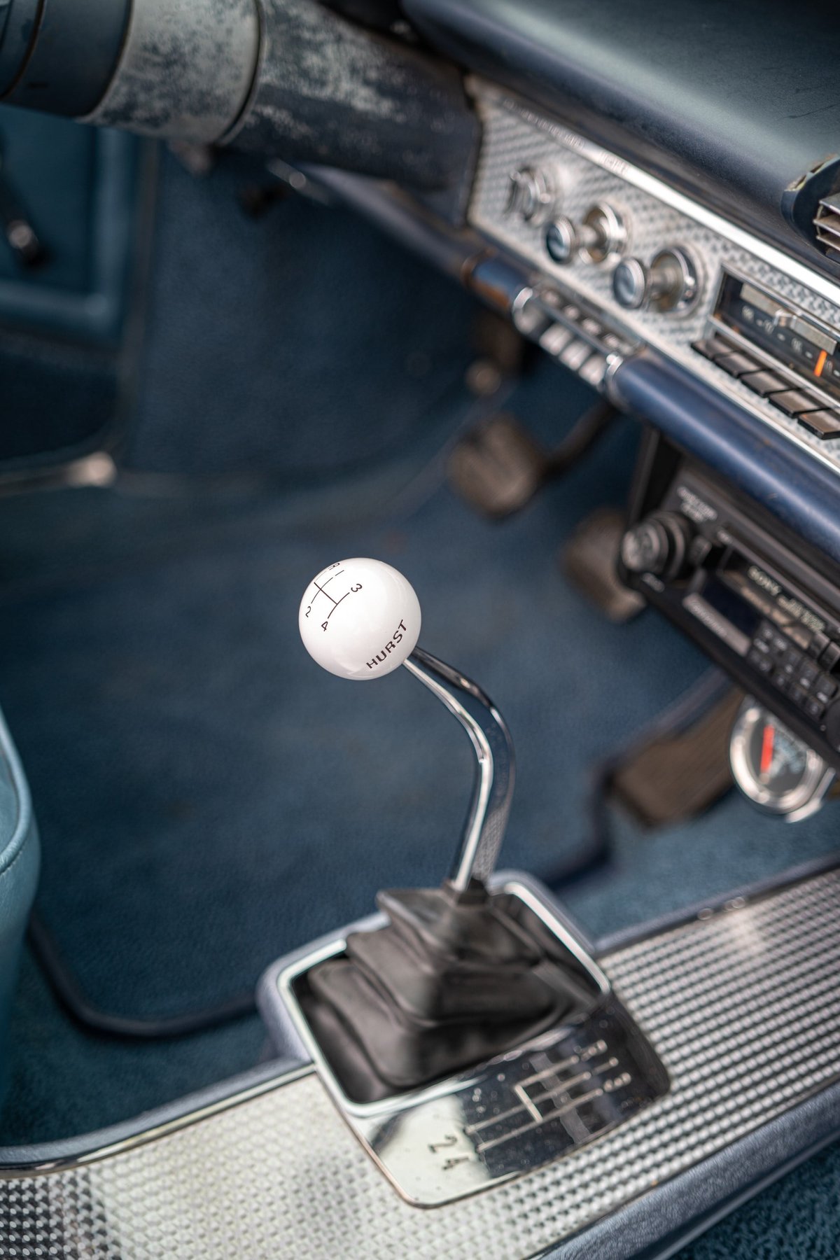 Vintage 1964 Chevrolet Impala SS interior with a Hurst 4-speed shifter and patterned trim.