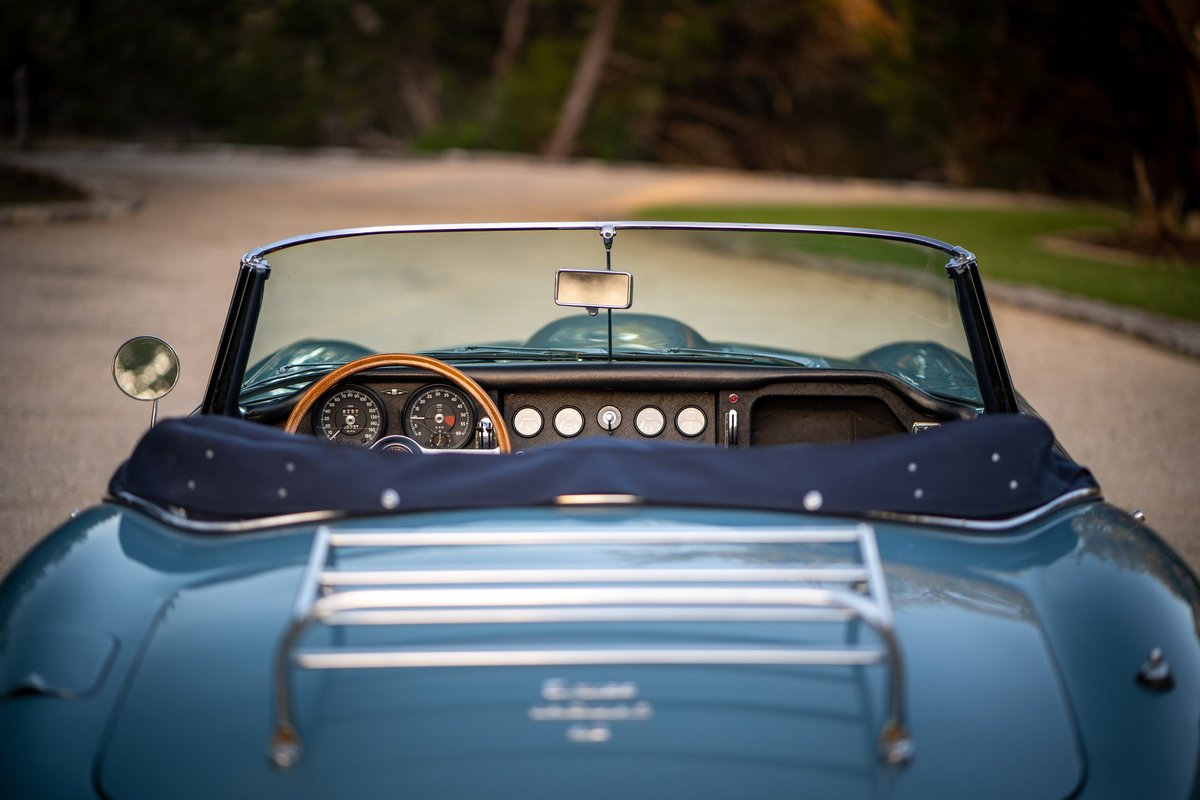 Opalescent silver-blue 1966 Jaguar XKE convertible interior and rear deck with luggage rack.