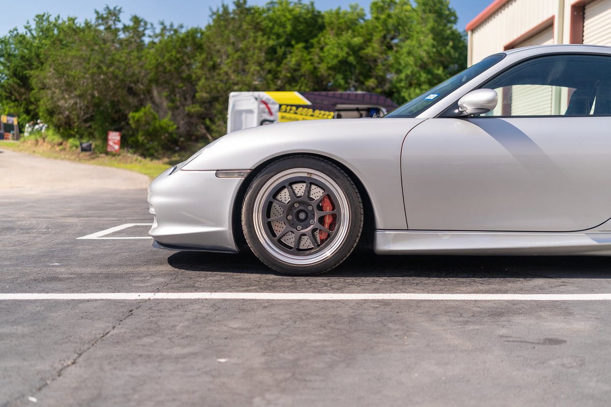 Silver Porsche 911 with multi-spoke rims and red brake calipers.