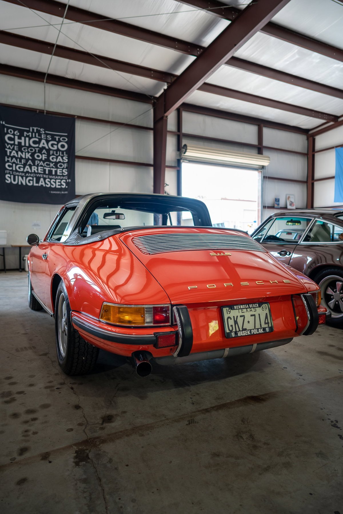Rear view of a red 1969 Porsche 911 Targa in a garage.