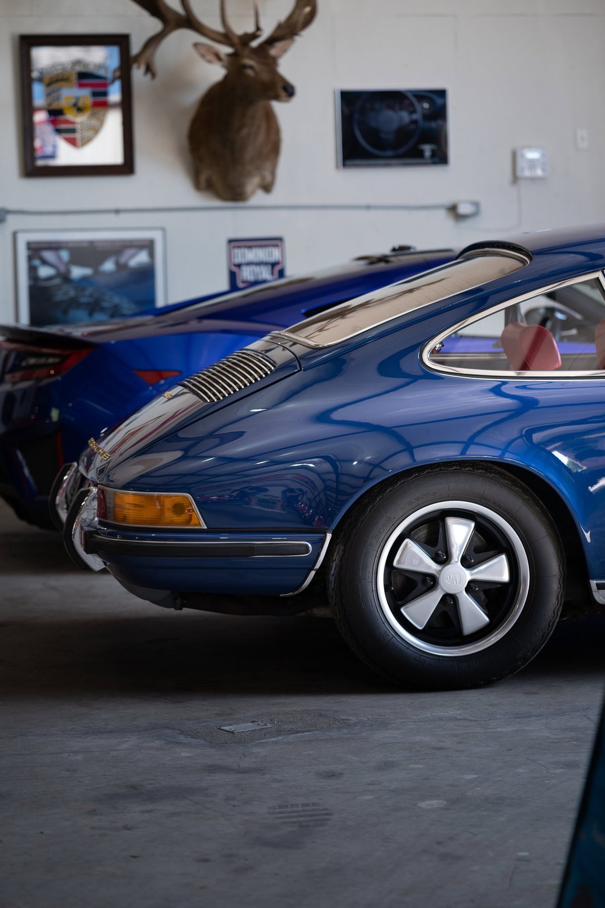 Blue Porsche 911 with silver alloy rims and chrome trim.