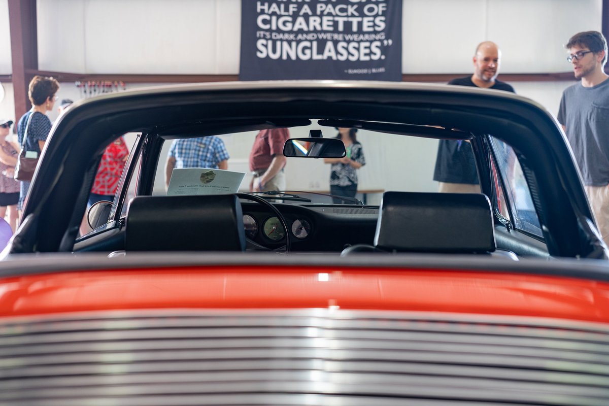 Interior rear view of a red Porsche Targa, showing dashboard and T-top headliner.
