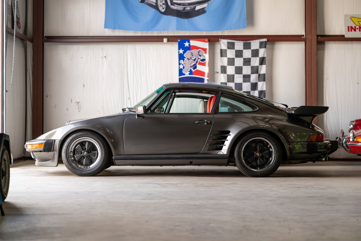 1980s Porsche 911 Turbo (930) in dark grey, Fuchs rims, black trim.