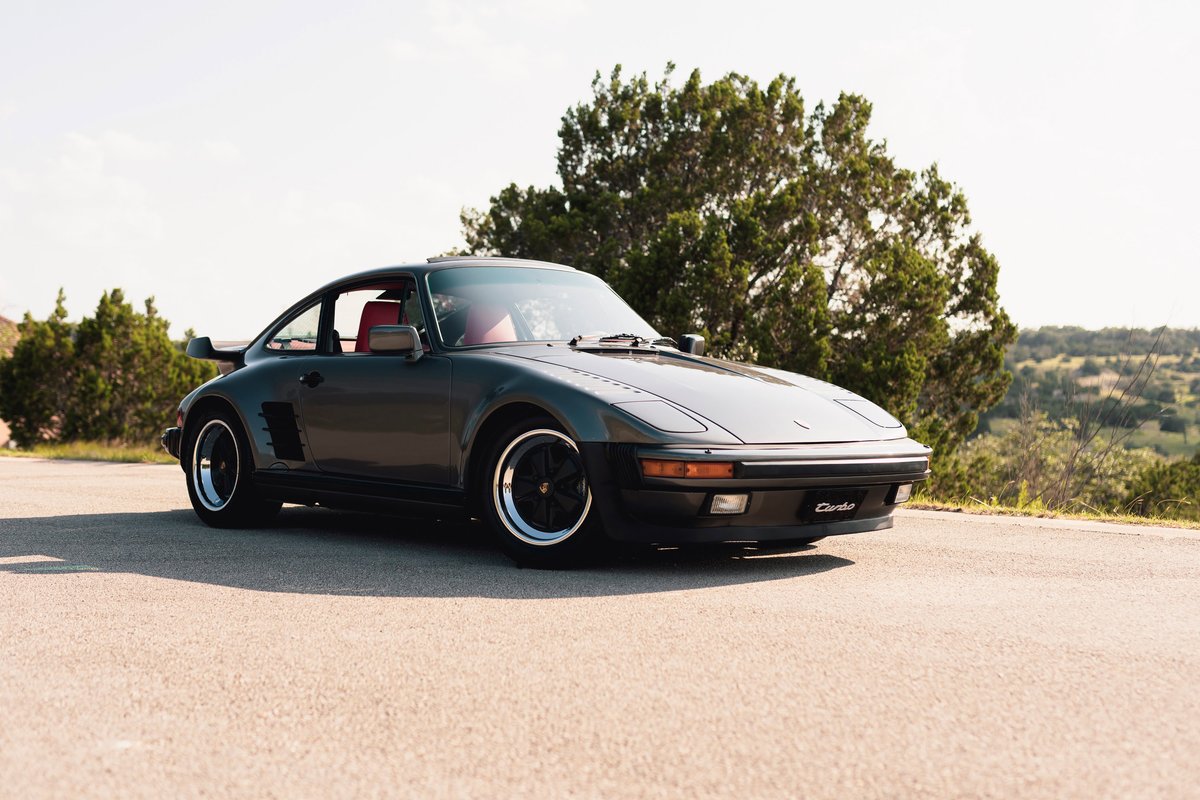 1989 Porsche 930 Turbo Flachbau in slate grey, with black and chrome rims and red interior.