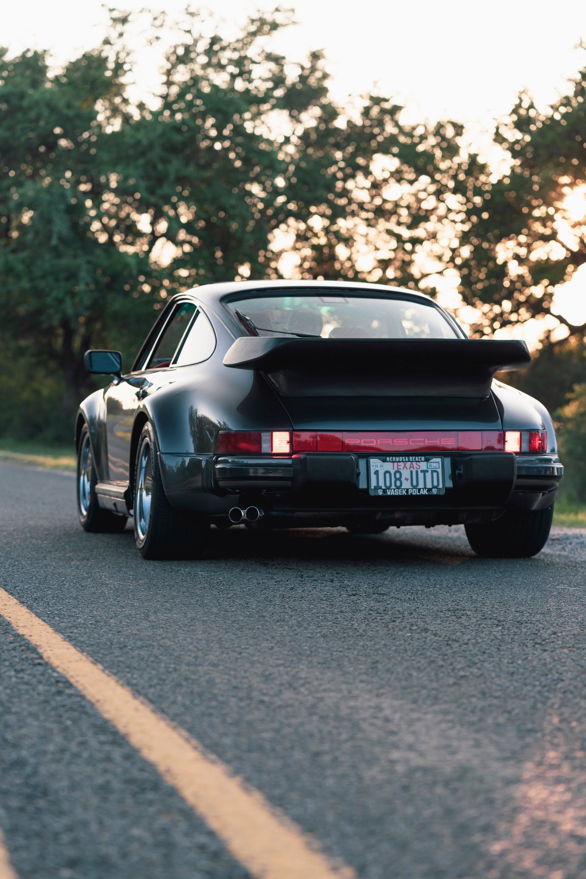 1989 Porsche 930 Turbo Flachbau coupe in black with whale tail spoiler.