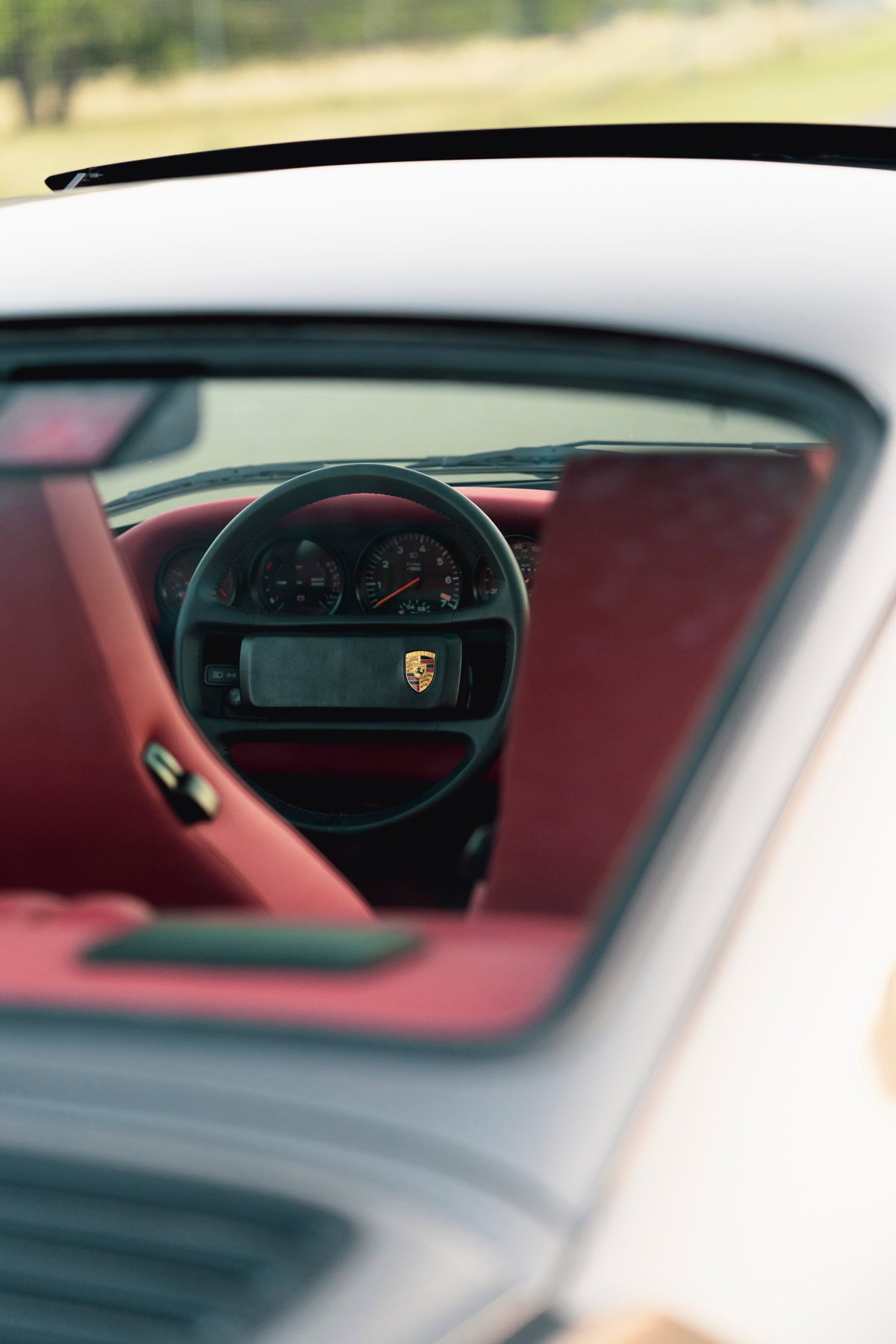 1989 Porsche 930 Turbo Flachbau interior with red leather seats, dashboard, and steering wheel.