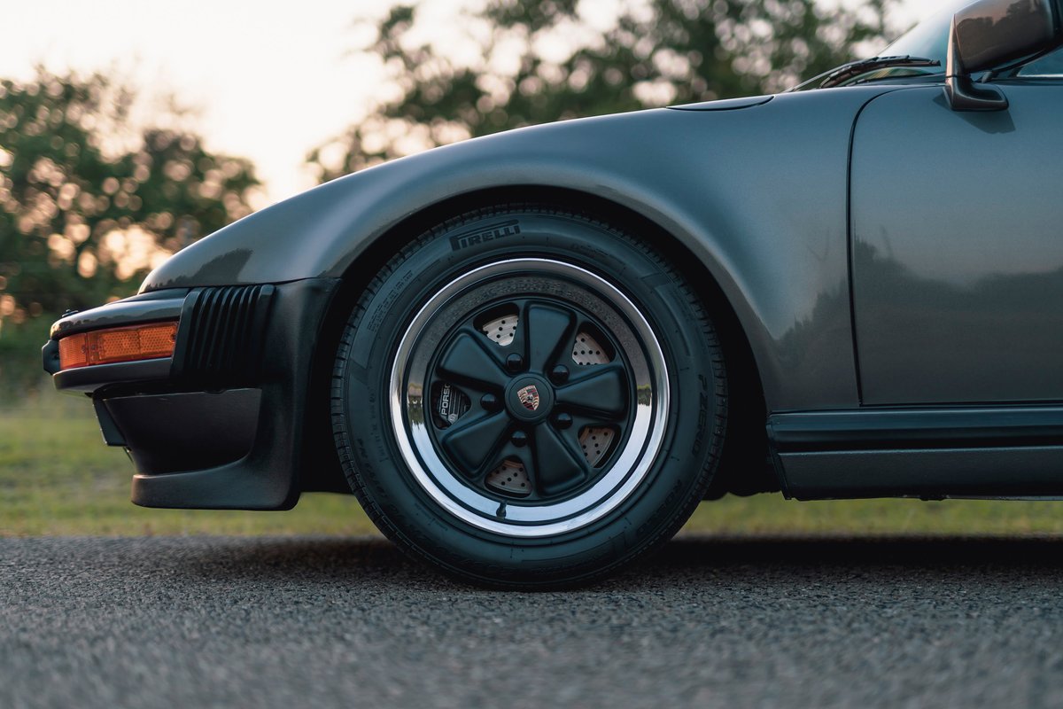 Close-up of a 1989 Porsche 930 Turbo Flachbau front wheel and fender.