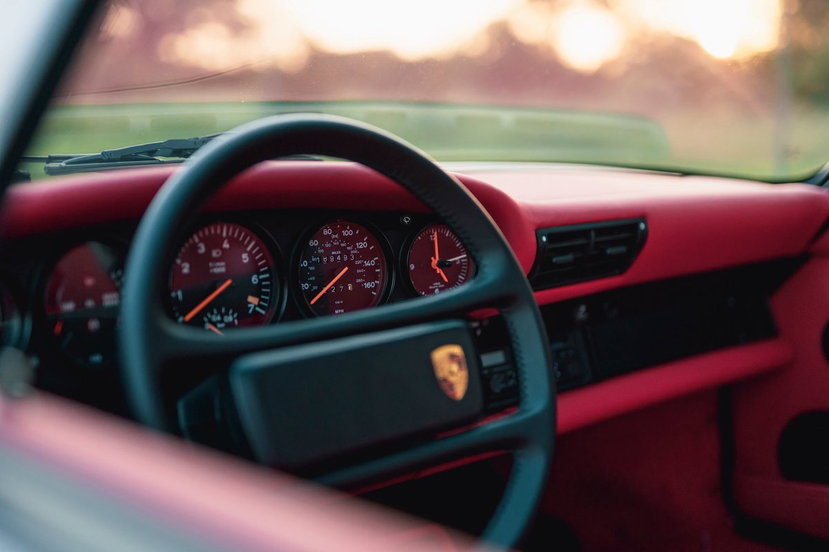 Interior of a 1989 Porsche 930 Turbo Flachbau with red trim and gauges.