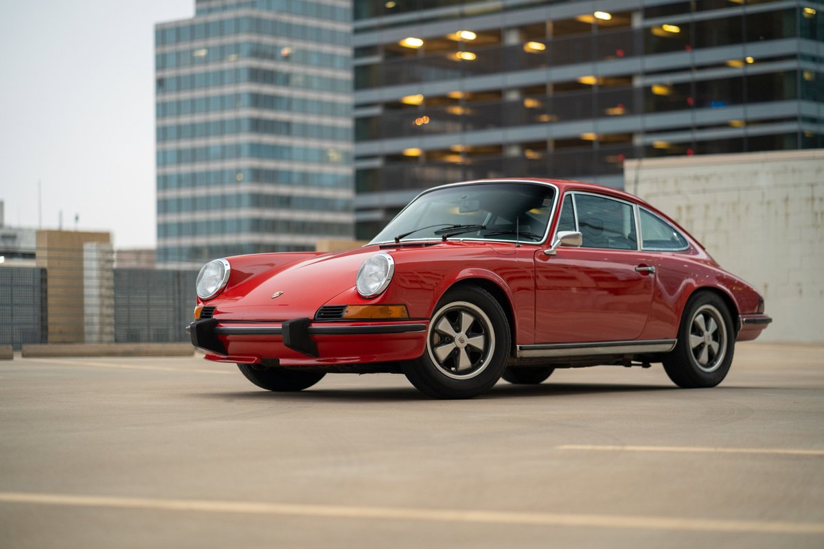 1973 Porsche 911S in Bahia Red with Fuchs rims, parked outdoors.
