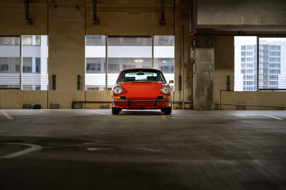 Bahia Red 1973 Porsche 911 S front view in parking garage.
