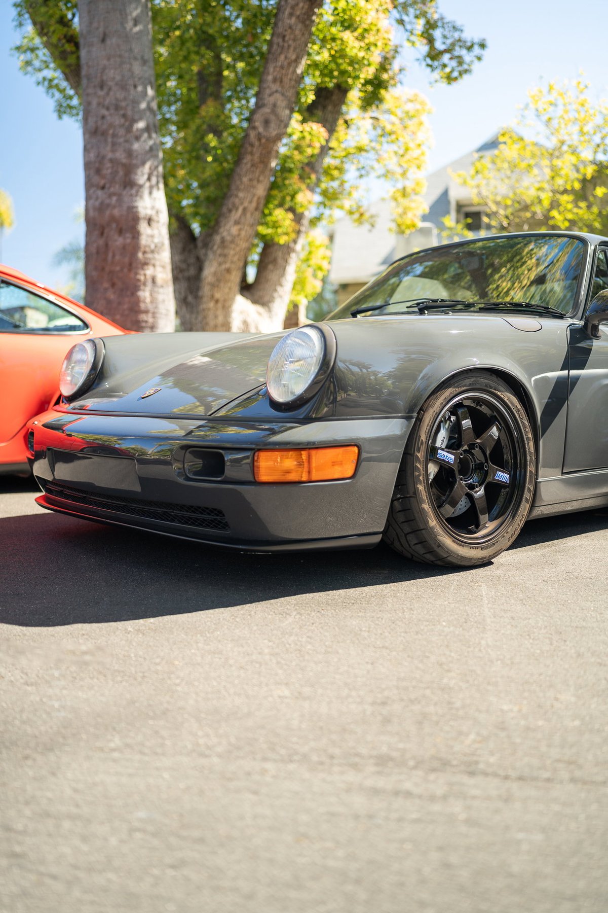Gray Porsche 911 (964) with black TE37 rims, front view.