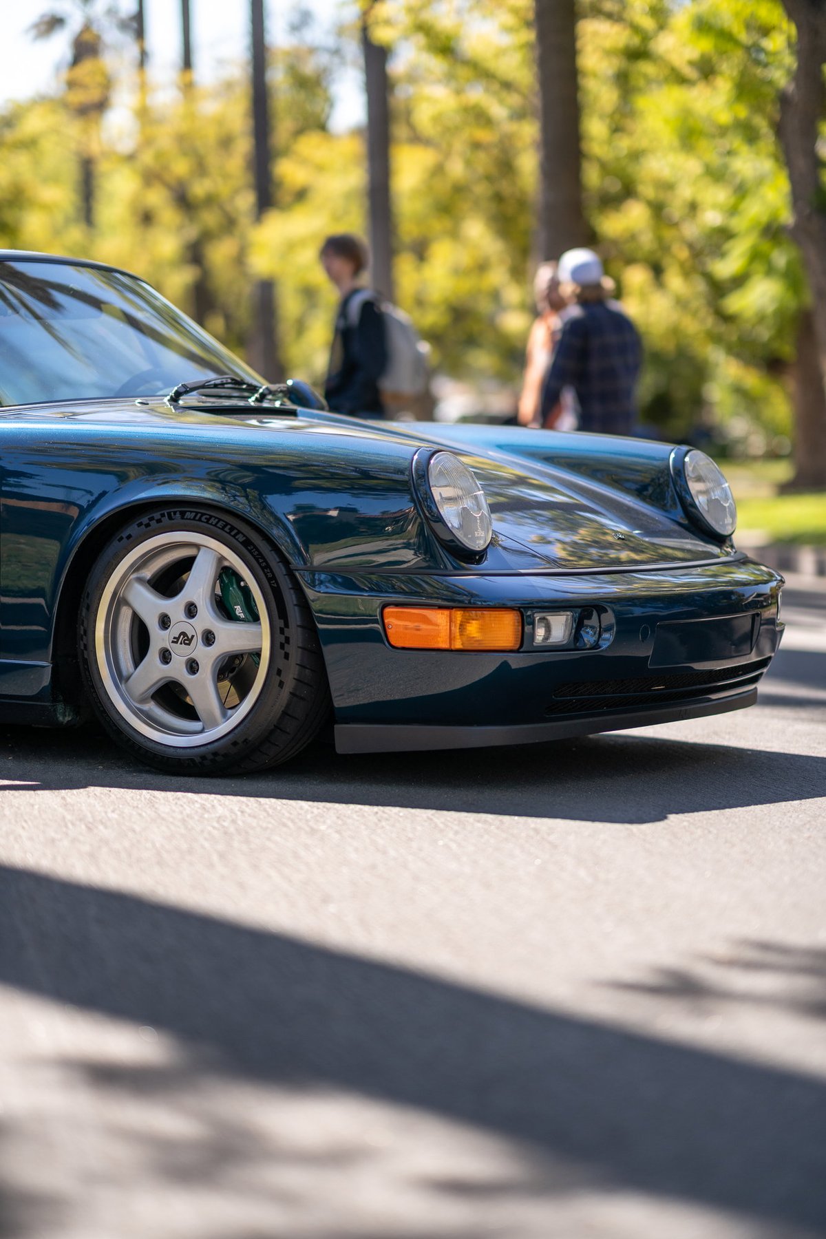Dark green Porsche 911 with silver RUF rims and green brake calipers.
