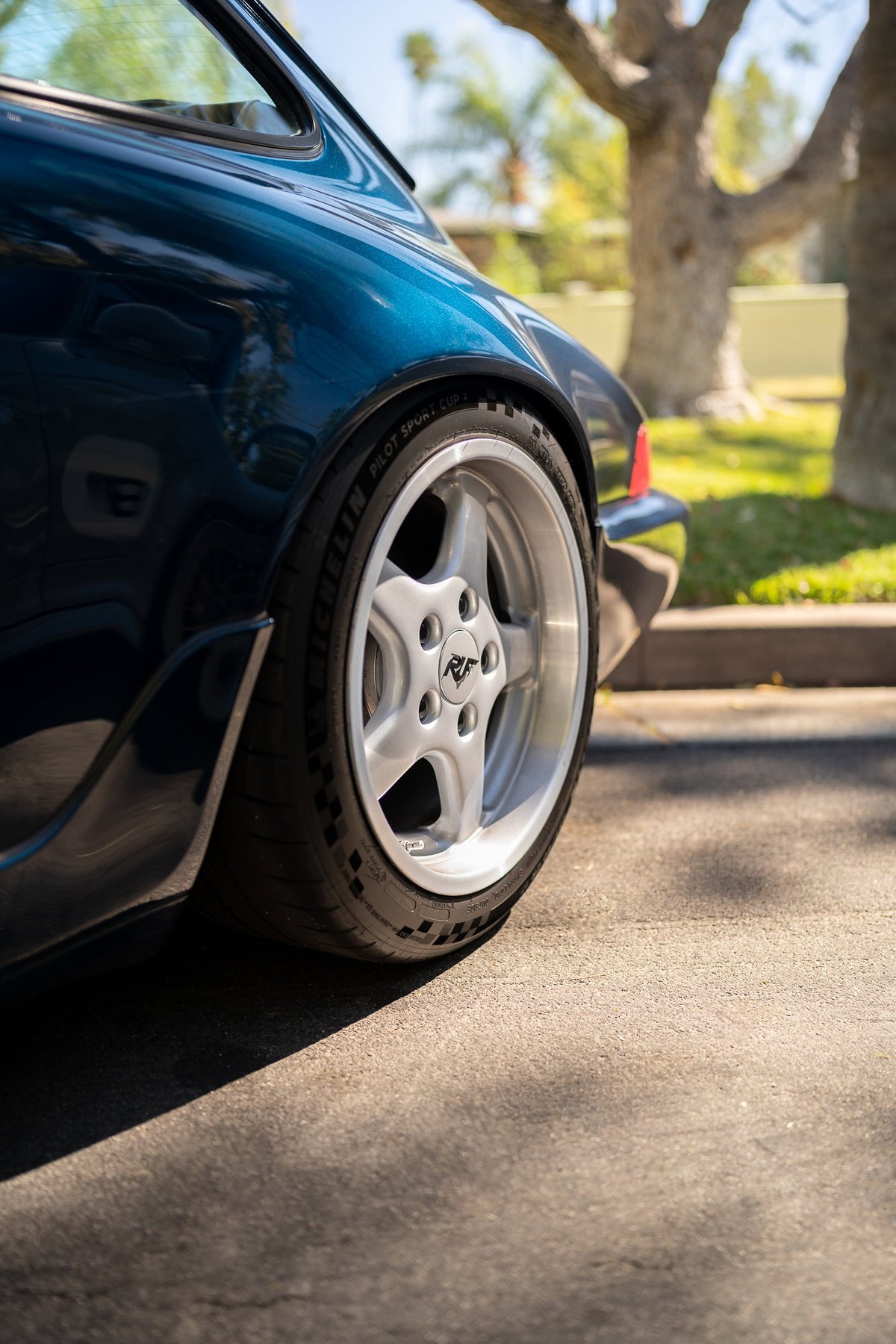 Deep blue Porsche 911 with silver RF five-spoke alloy rims and Michelin tires.