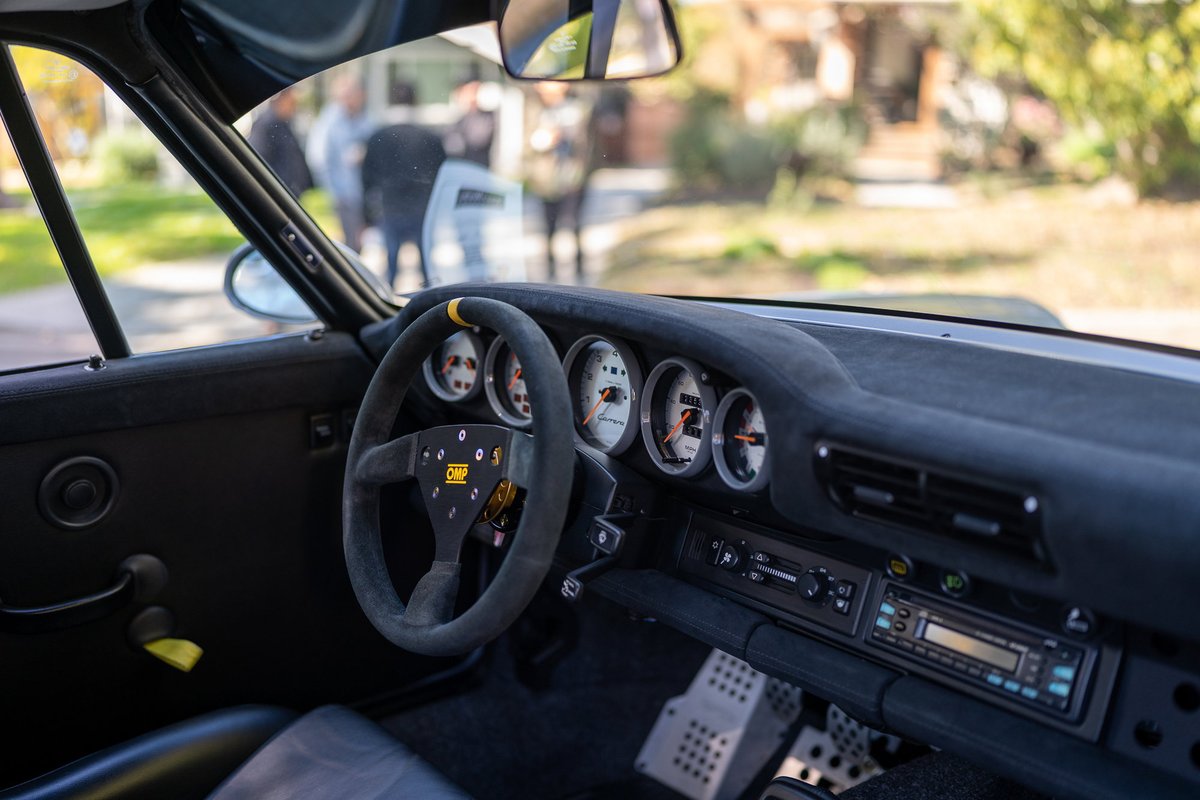 Porsche 911 interior with OMP racing wheel, period correct stereo, and rally pedals.