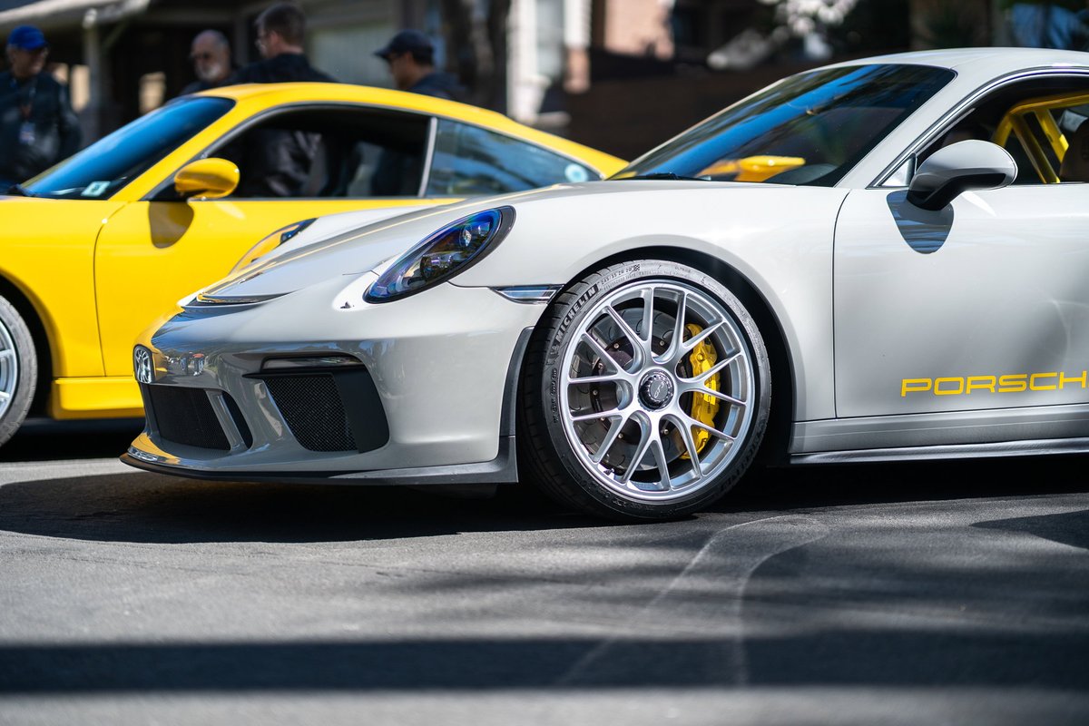 Silver Porsche 911 GT3 with yellow livery and yellow brake calipers.