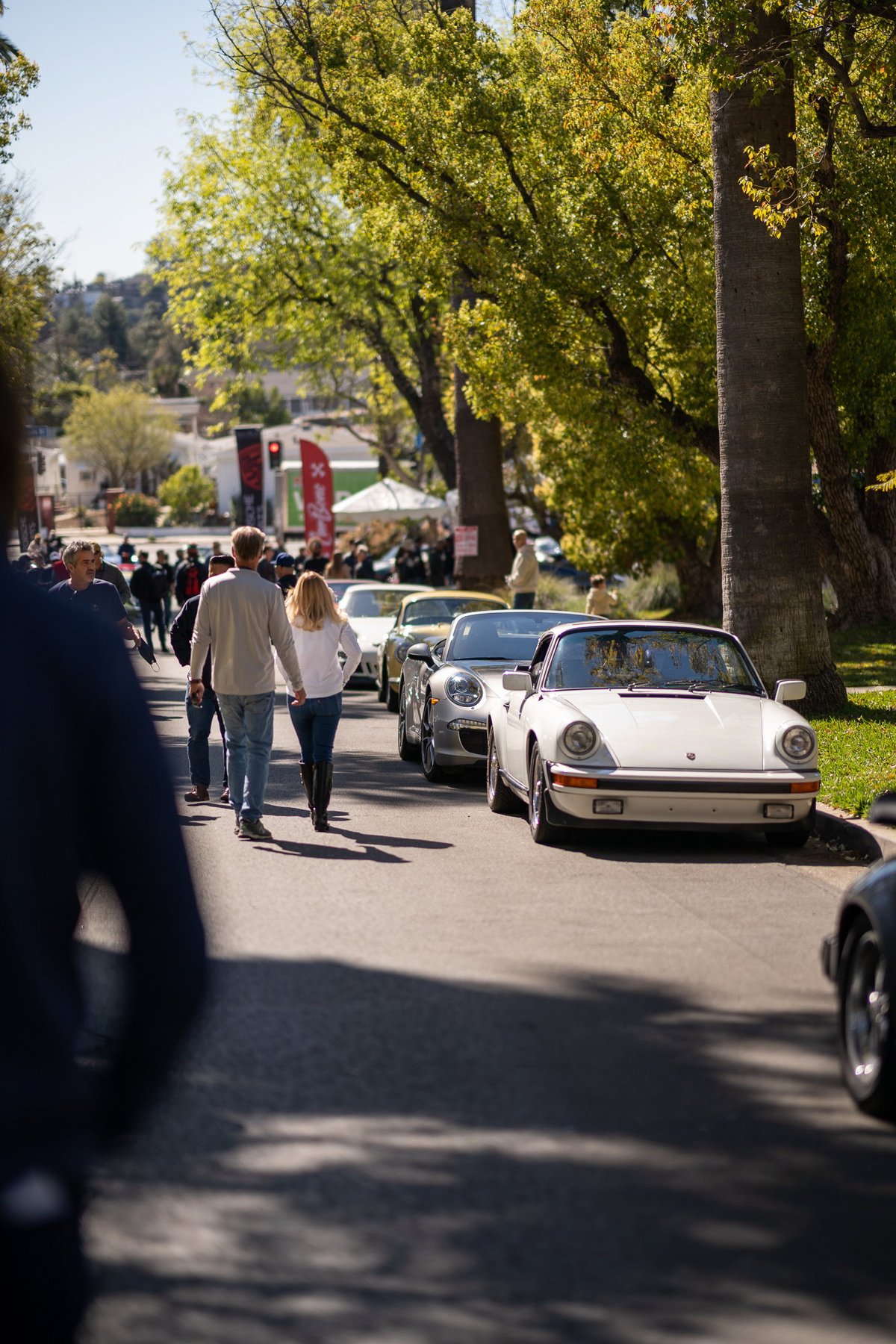 White 1980s Porsche 911 SC, silver Porsche 911, and yellow Porsche 911 at Lit Show, Los Angeles.