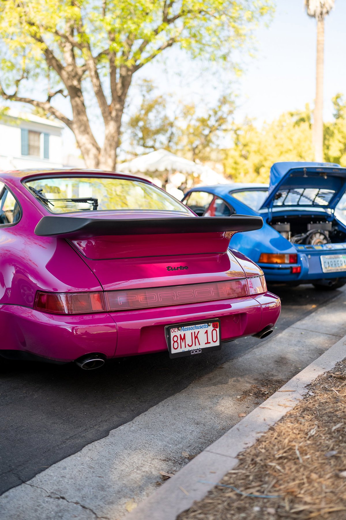 Pink Porsche 911 Turbo with large spoiler. Blue Porsche Carrera behind it.