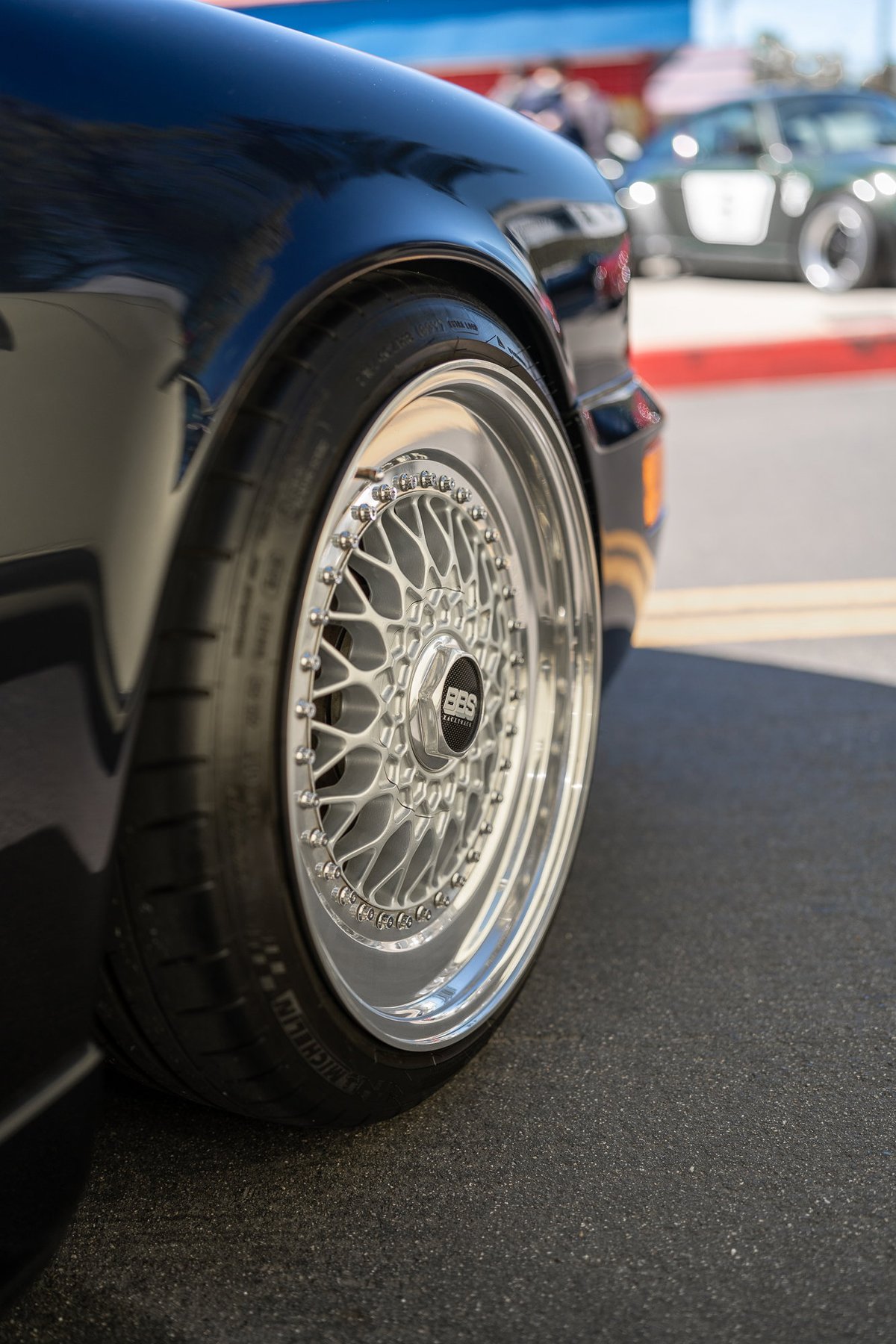 Black Porsche 911 with BBS mesh rims and polished lips.