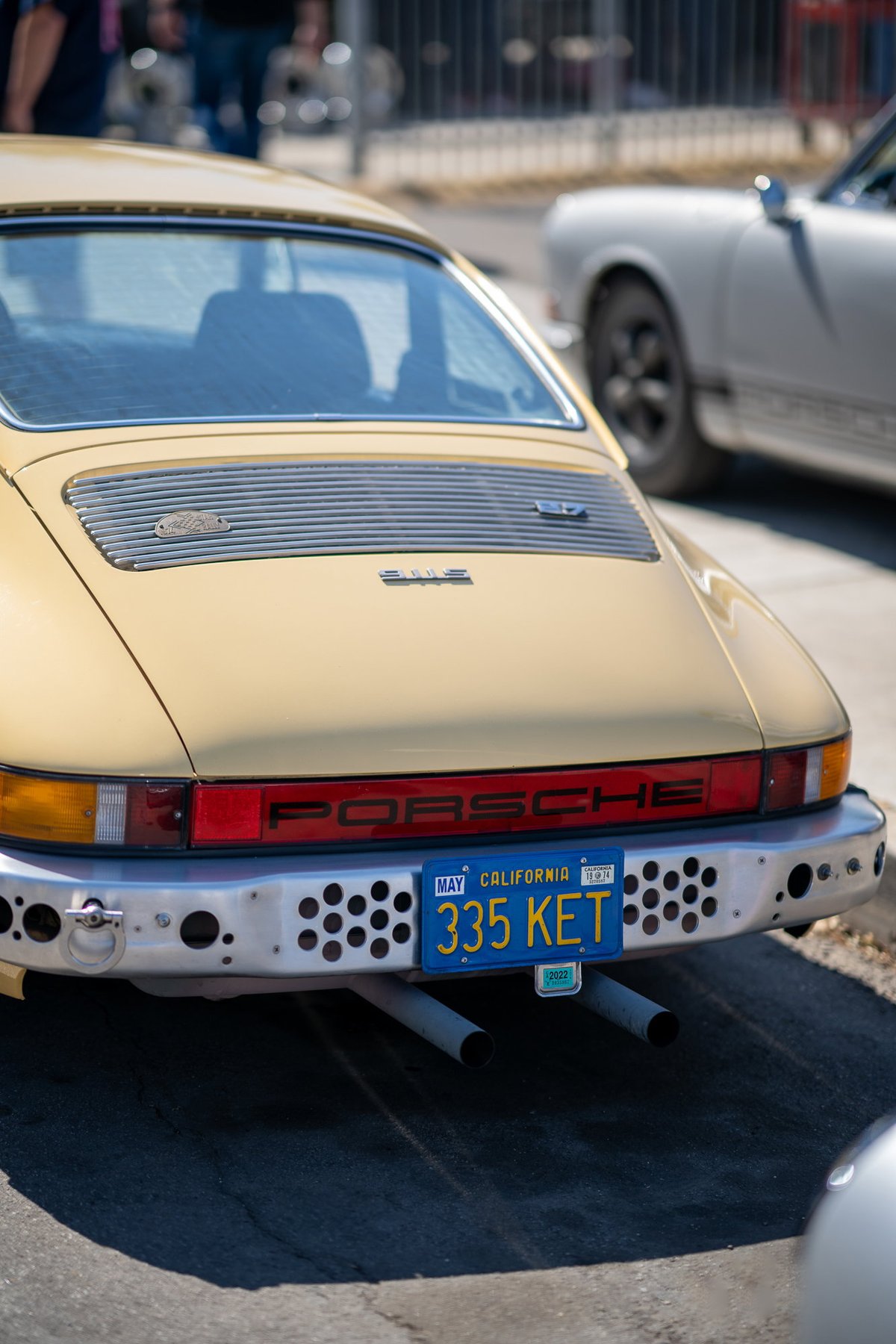 Rear view of a tan Porsche 911 with California plate "335 KET".