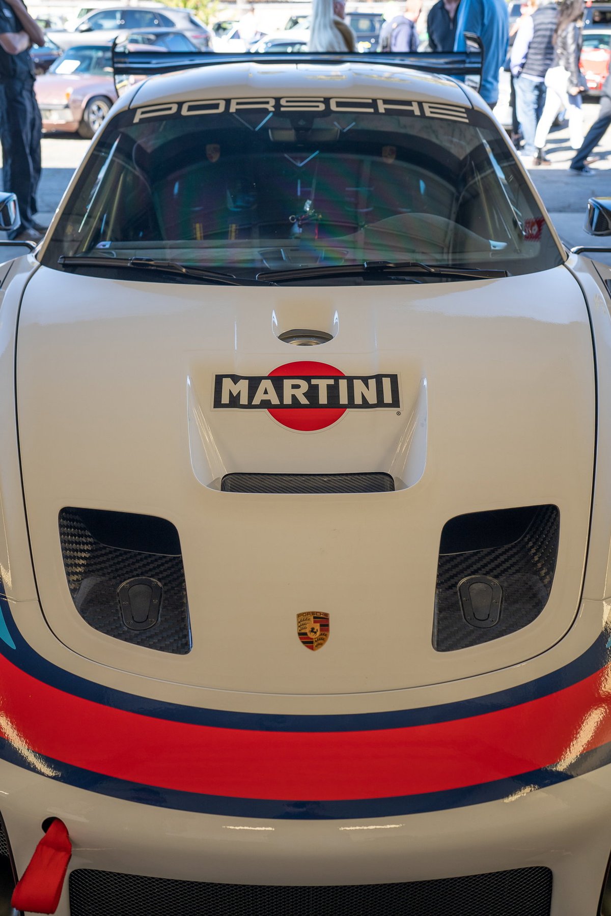 White Porsche 911 race car with Martini livery and carbon fiber accents.