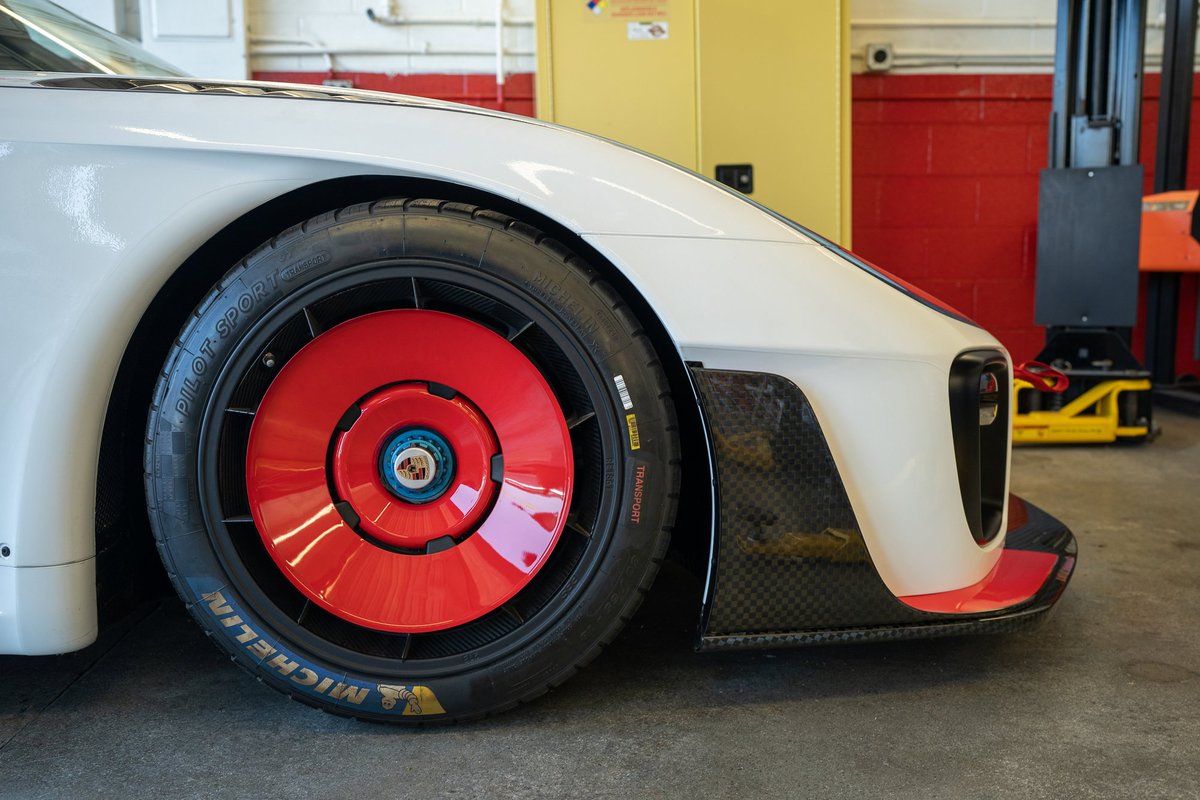 White Porsche 935 with red aero disc wheels and carbon fiber trim.