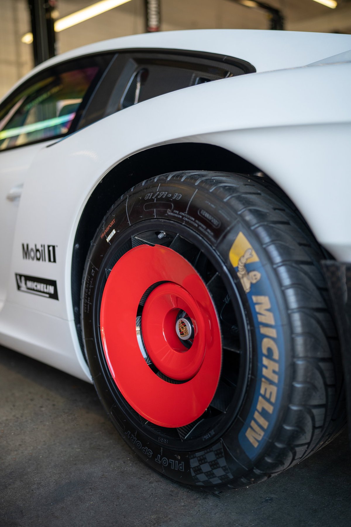 White Porsche 911 with red aero disc wheels and Michelin Pilot Sport tires.