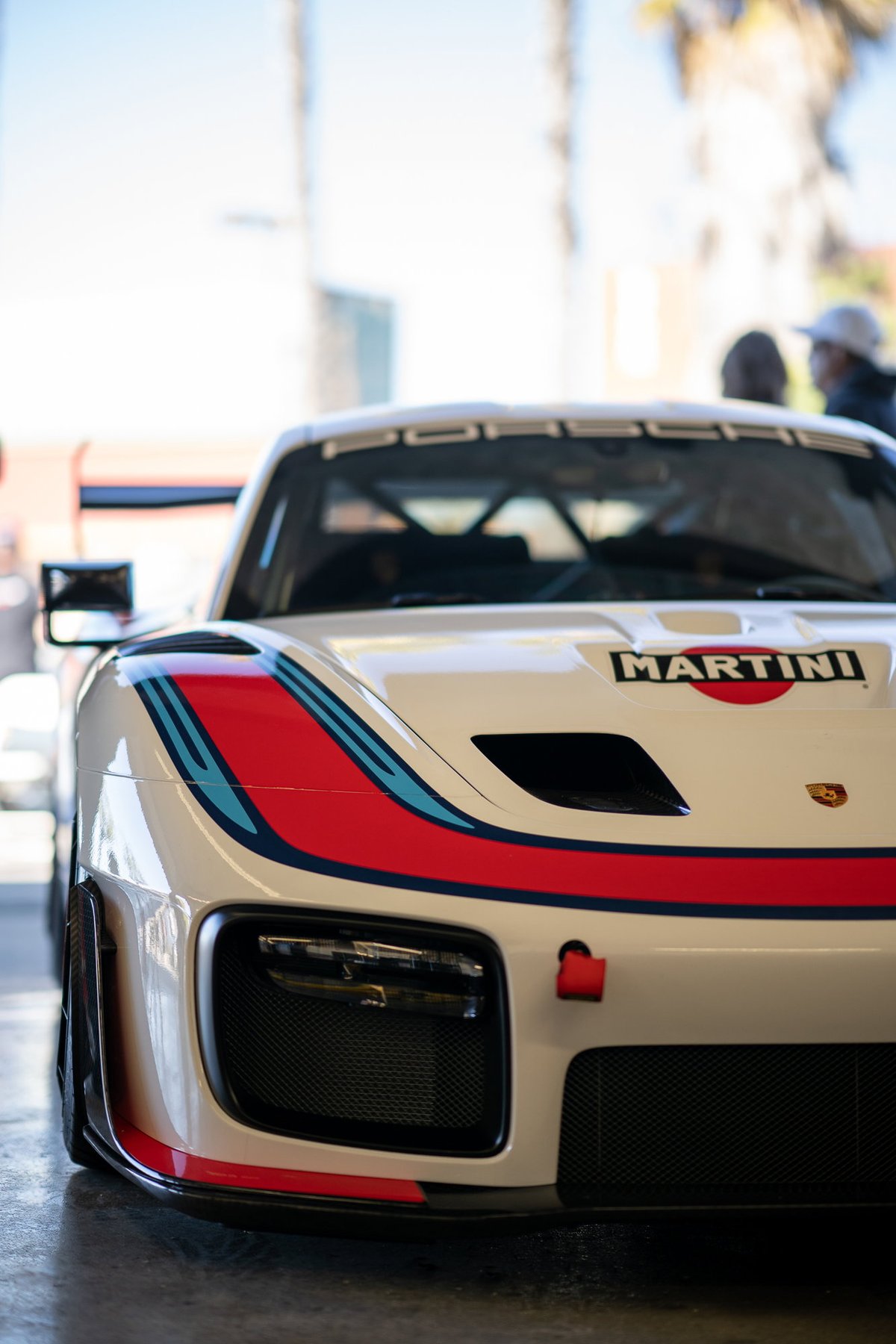 White Porsche 935 with iconic Martini Racing livery, front view.