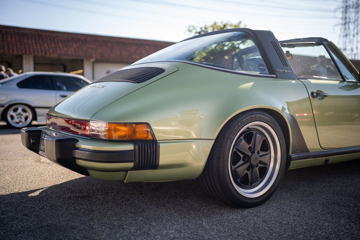 Green Porsche 911 Targa with black Fuchs rims and black trim.