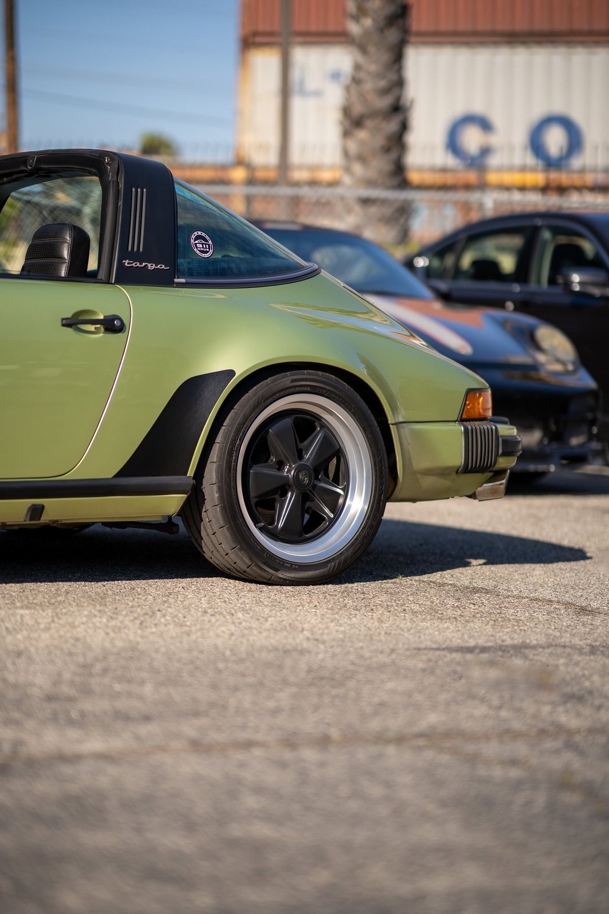 1970s Porsche 911 Targa in lime green with black trim and Fuchs wheels.