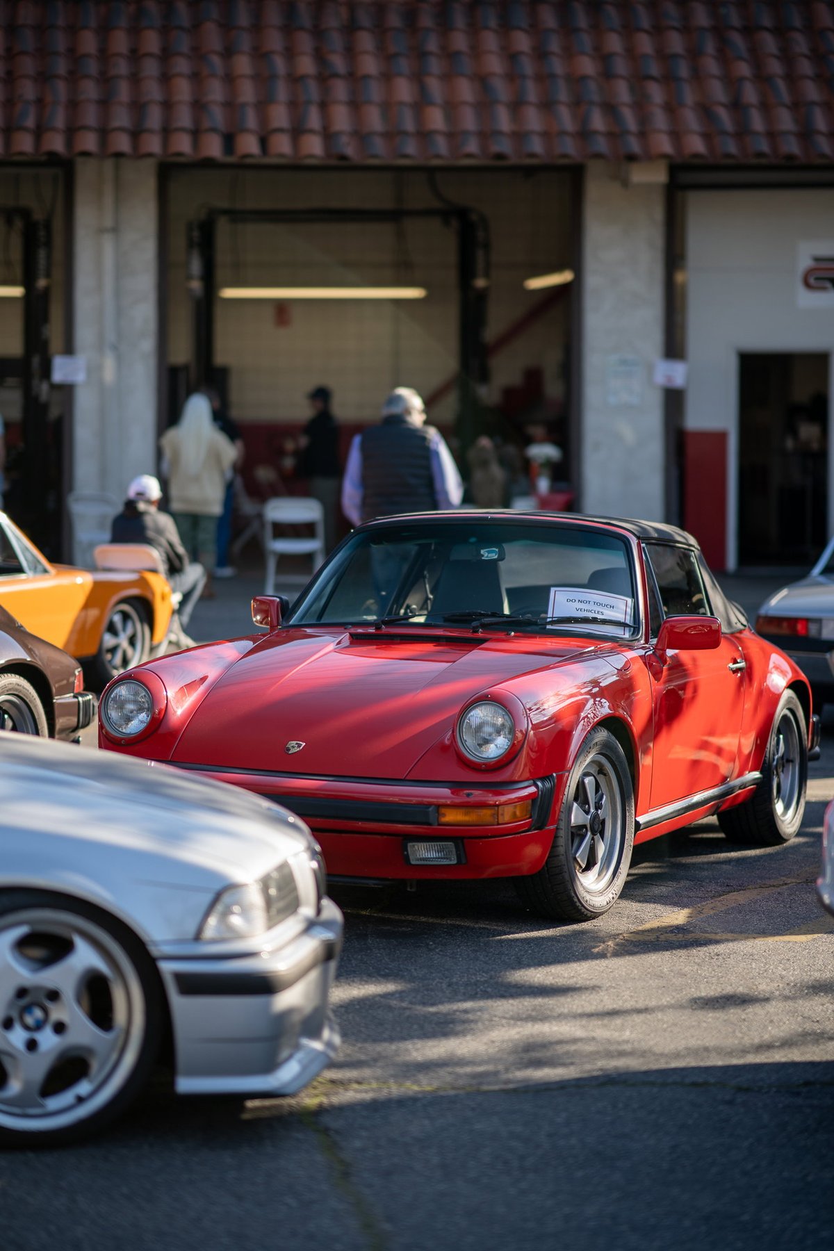 Red 1980s Porsche 911 Targa with black trim and Fuchs rims.