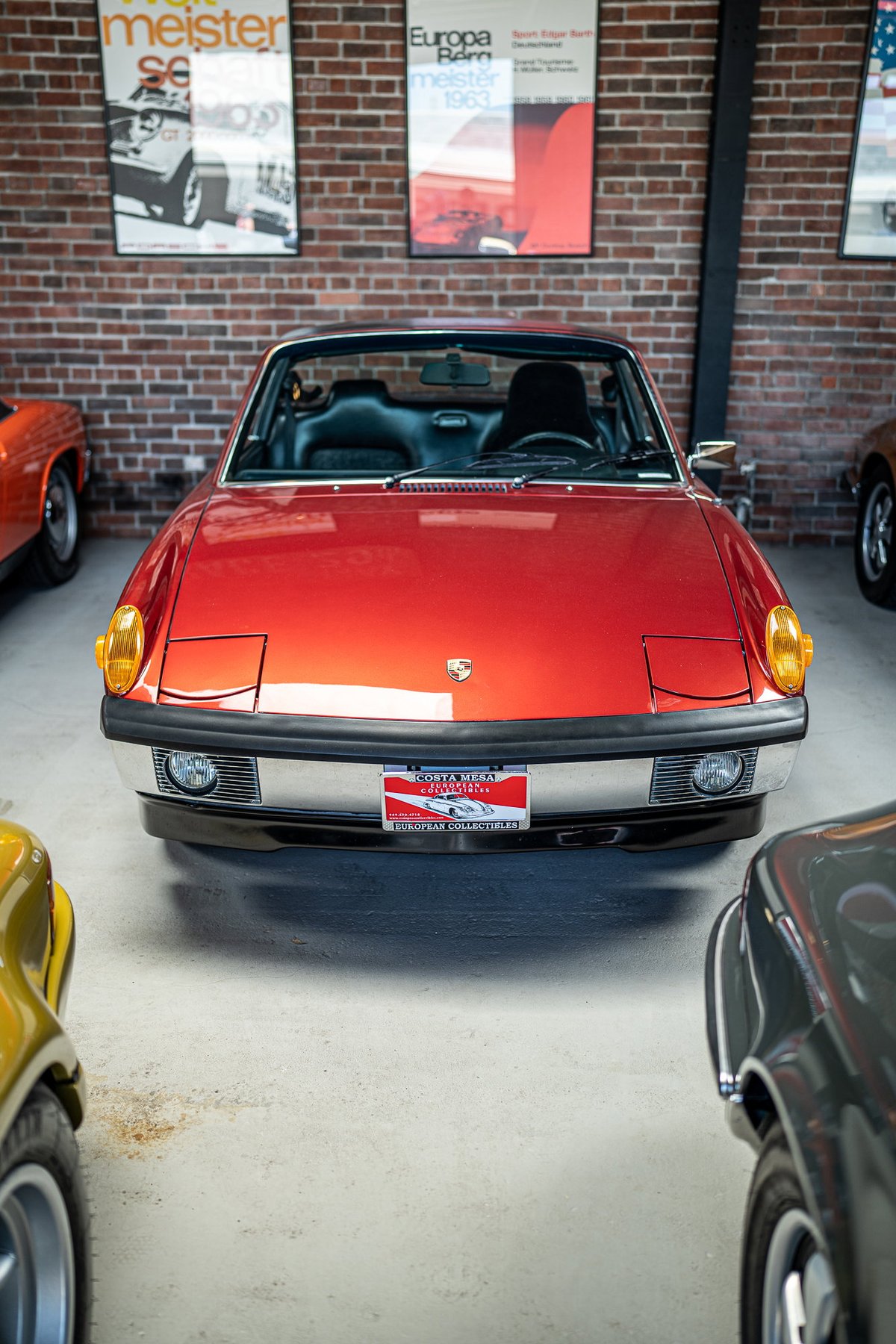 Red Porsche 914 with chrome trim, pop-up headlights, and front plate.